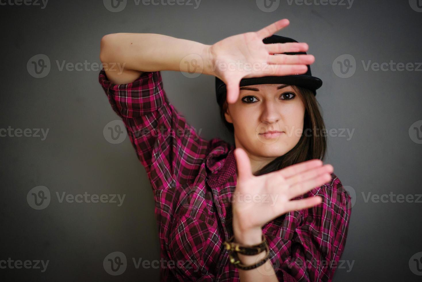 Portrait of brunette girl with cap wearing casual clothes background gray wall. photo