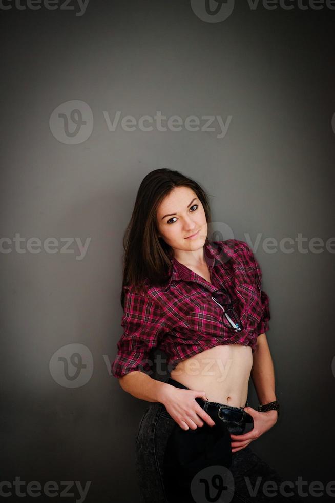 Portrait of brunette girl with cap wearing casual clothes background gray wall. photo