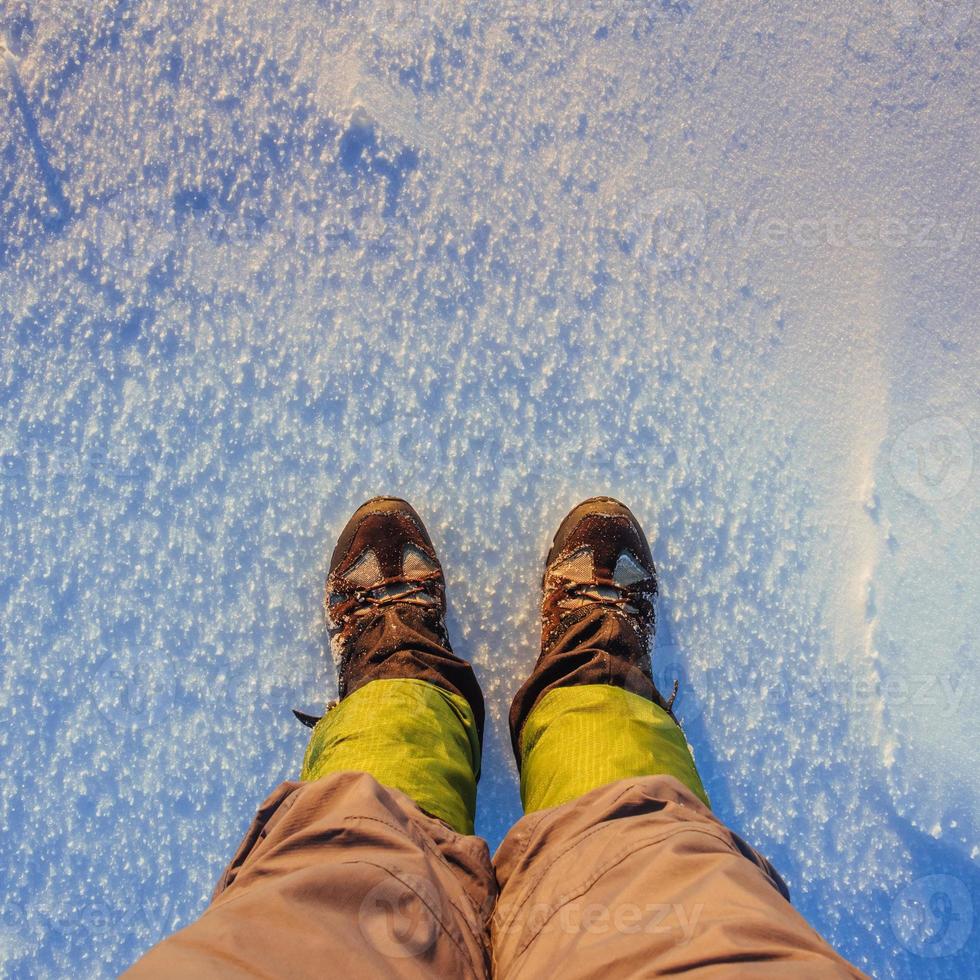 Tourist considering his shoes in the snow photo