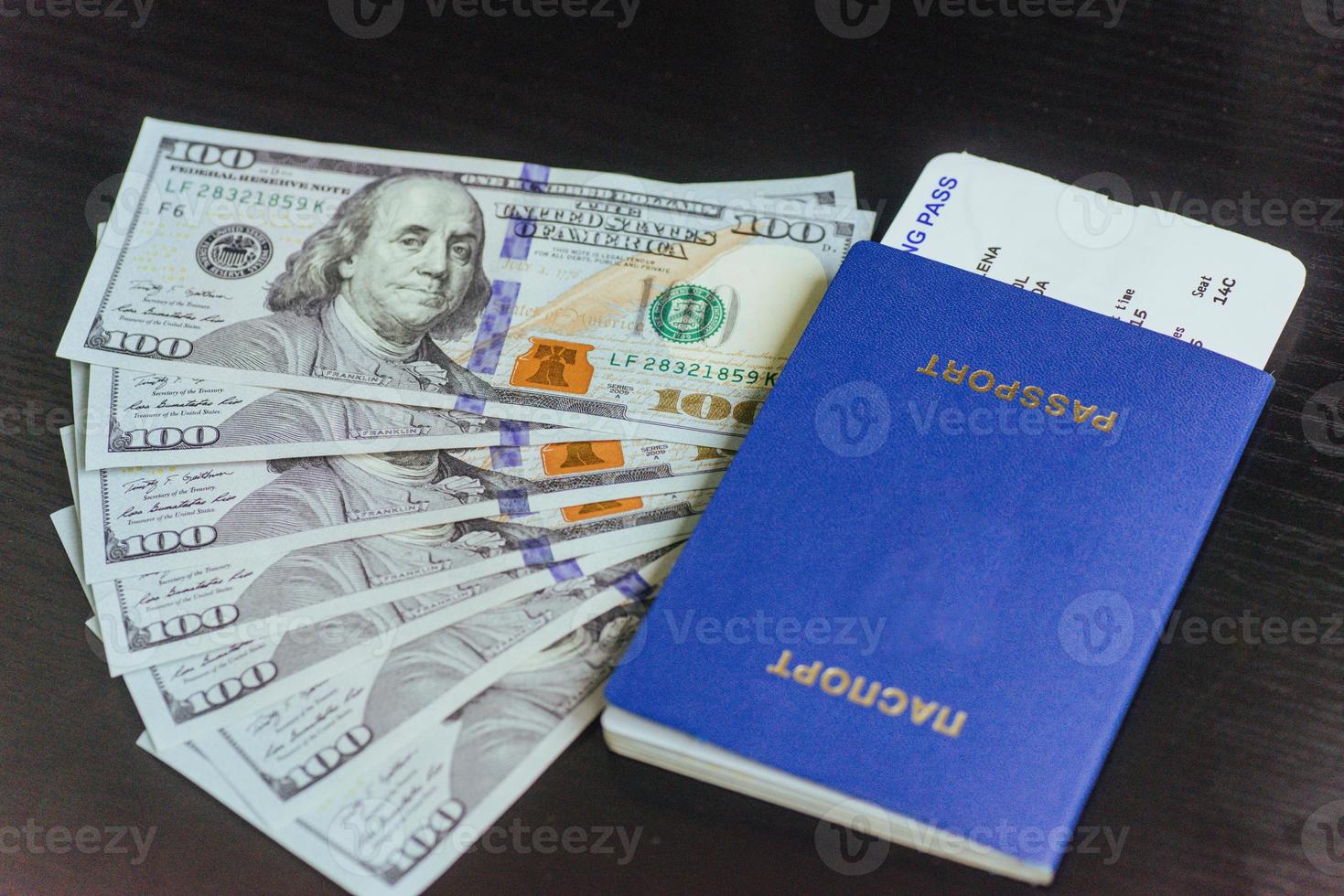 Top view of passport with dollar banknotes on wooden desktop photo