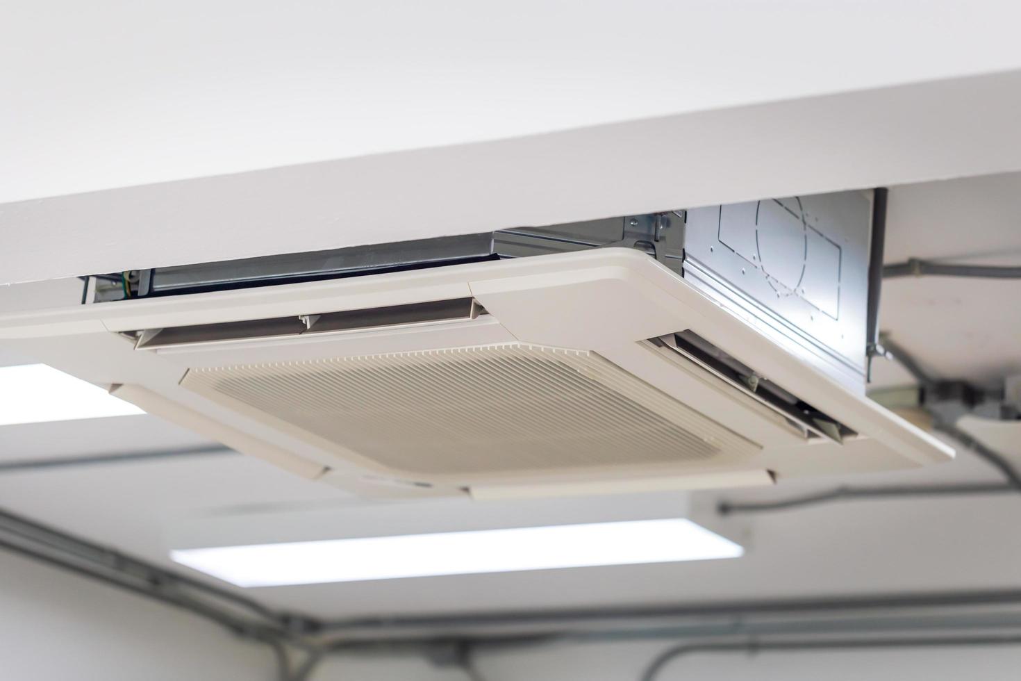moderno sistema de aire acondicionado tipo casete montado en el techo en una cafetería foto