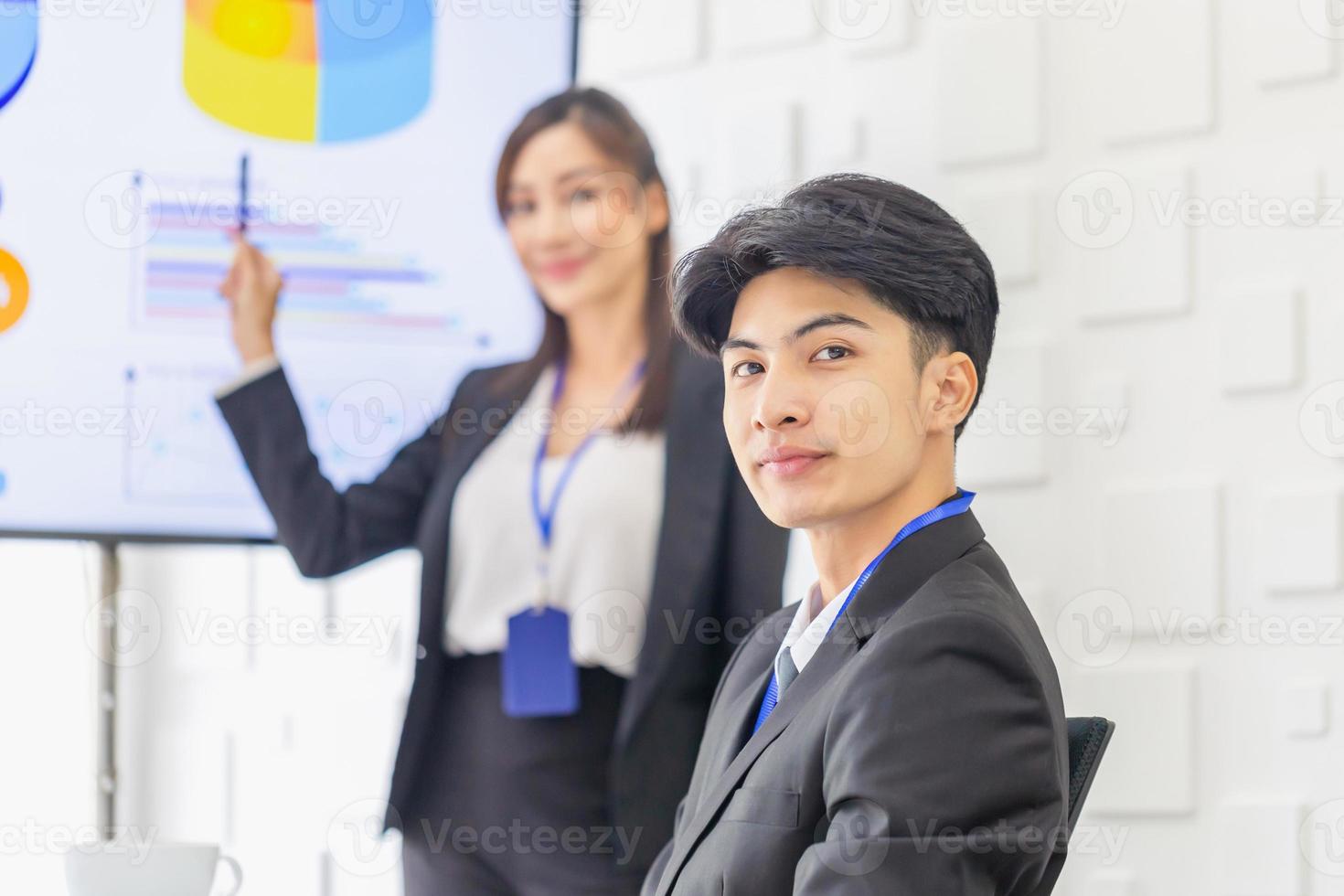 Young business people meeting and share idea at office, Office worker discussing together in conference room during meeting with blurred business woman making a presentation in front of board photo
