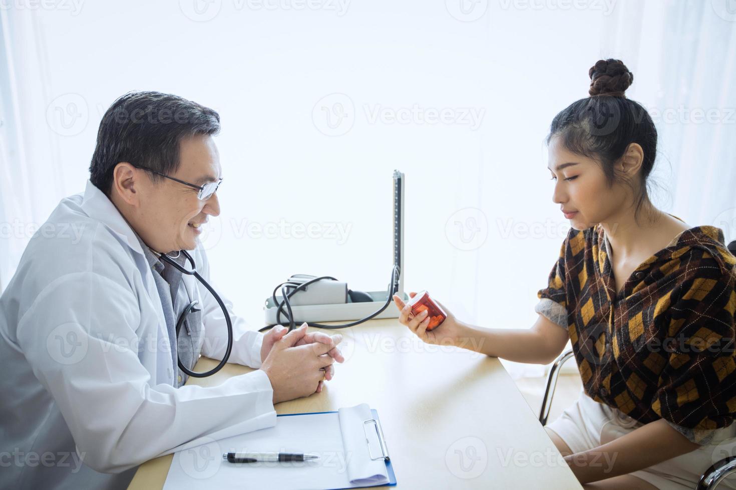 el doctor está preguntando y explicando la enfermedad y dando la medicina. con pacientes femeninas en su oficina en el hospital. foto