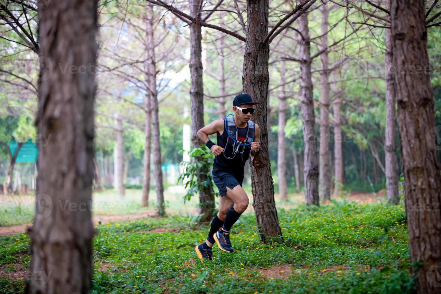 A man Runner of Trail and athlete's feet wearing sports shoes for trail running in the forest photo