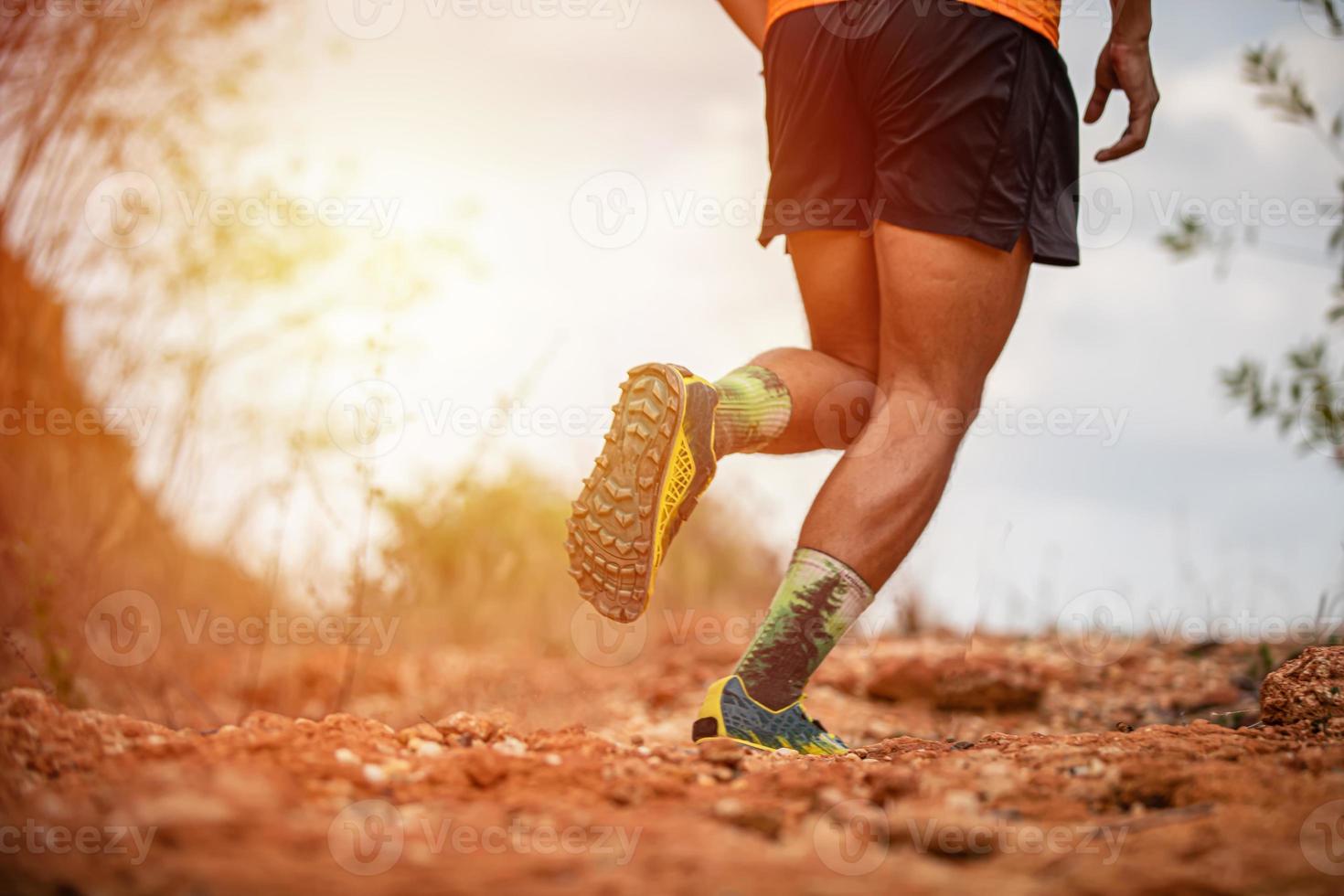 A man Runner of Trail and athlete's feet wearing sports shoes for trail running in the mountain photo