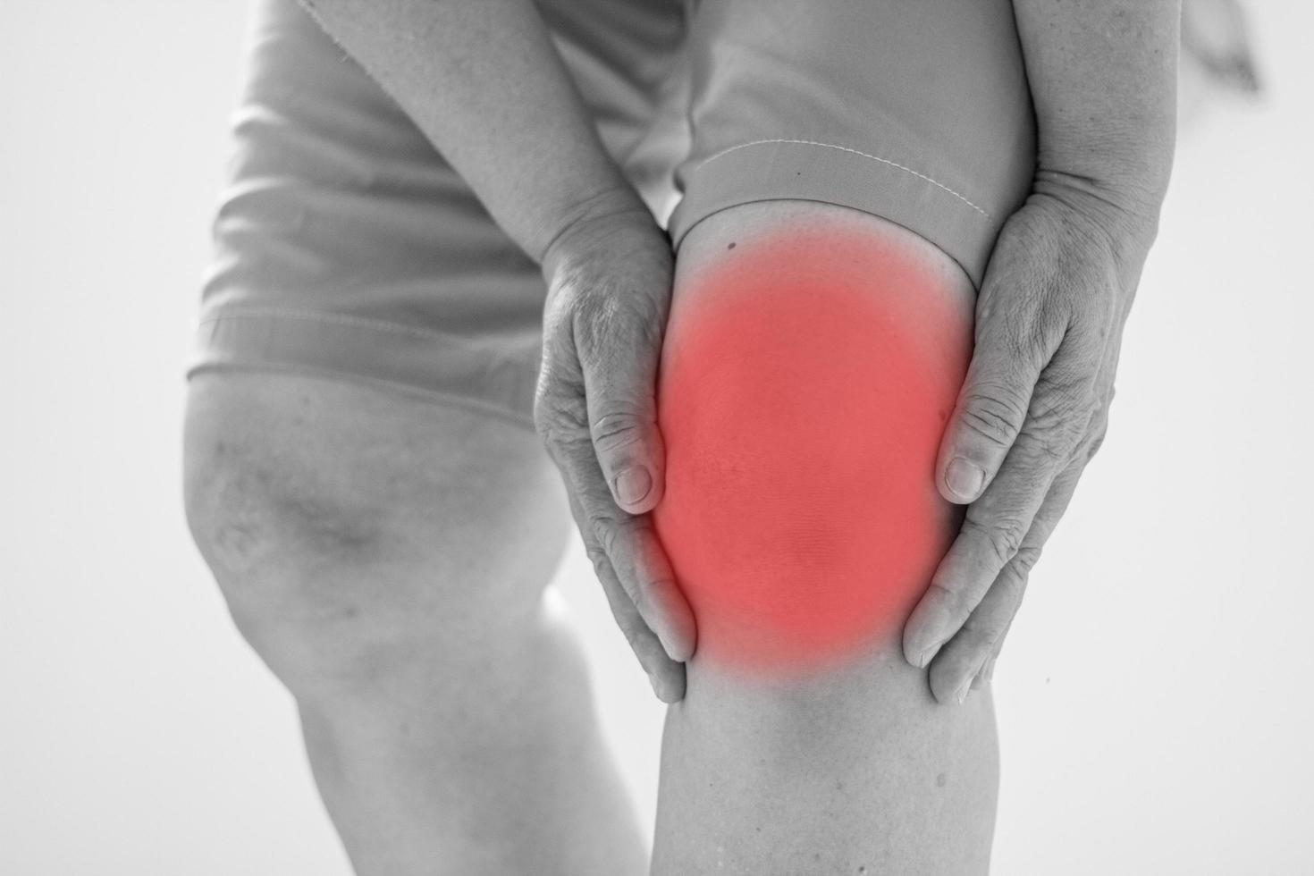 Old Asian women to knee injury on white background,black and white tone photo