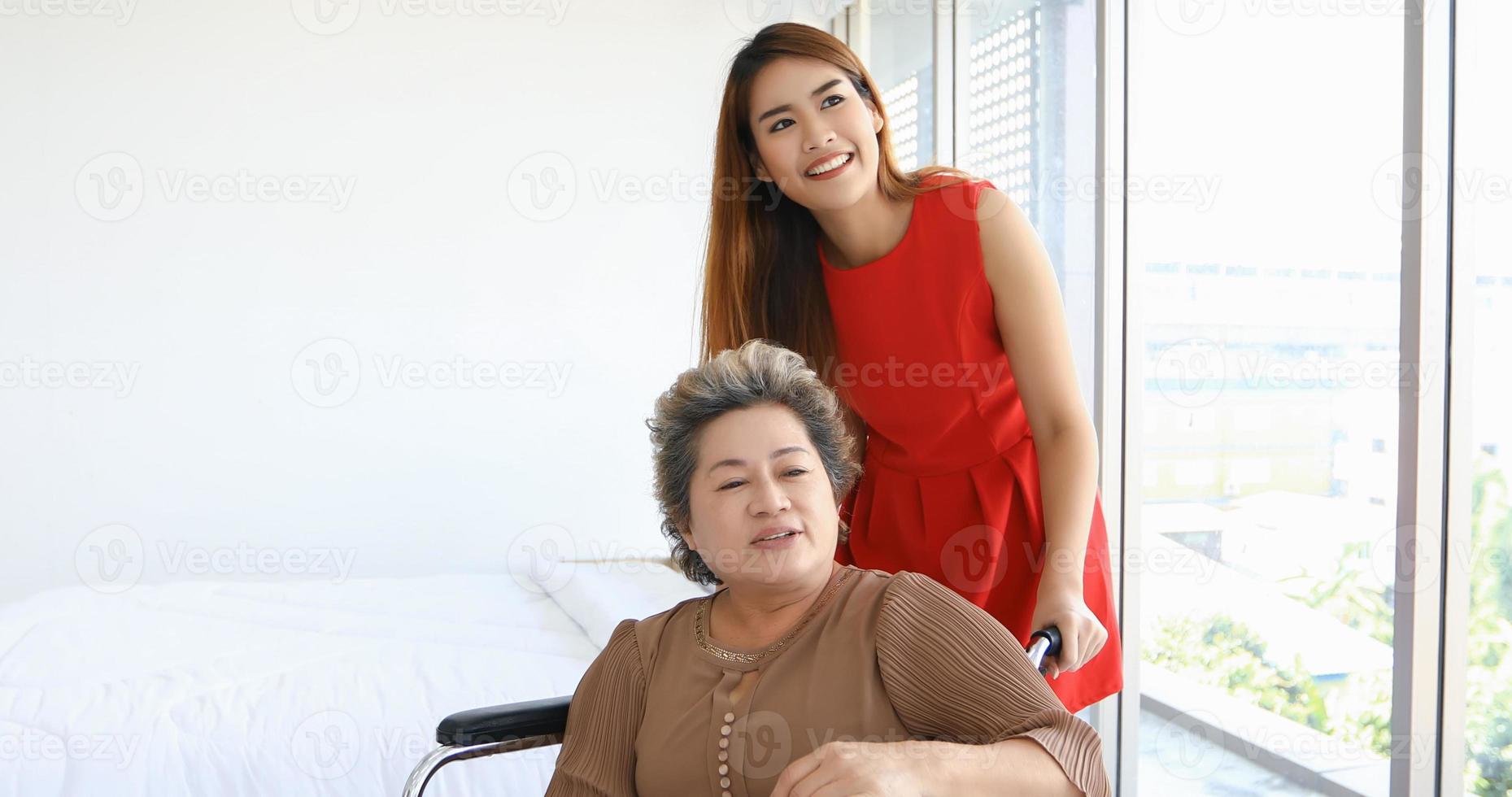 Asian woman take care of her grandmother in wheelchair at home photo