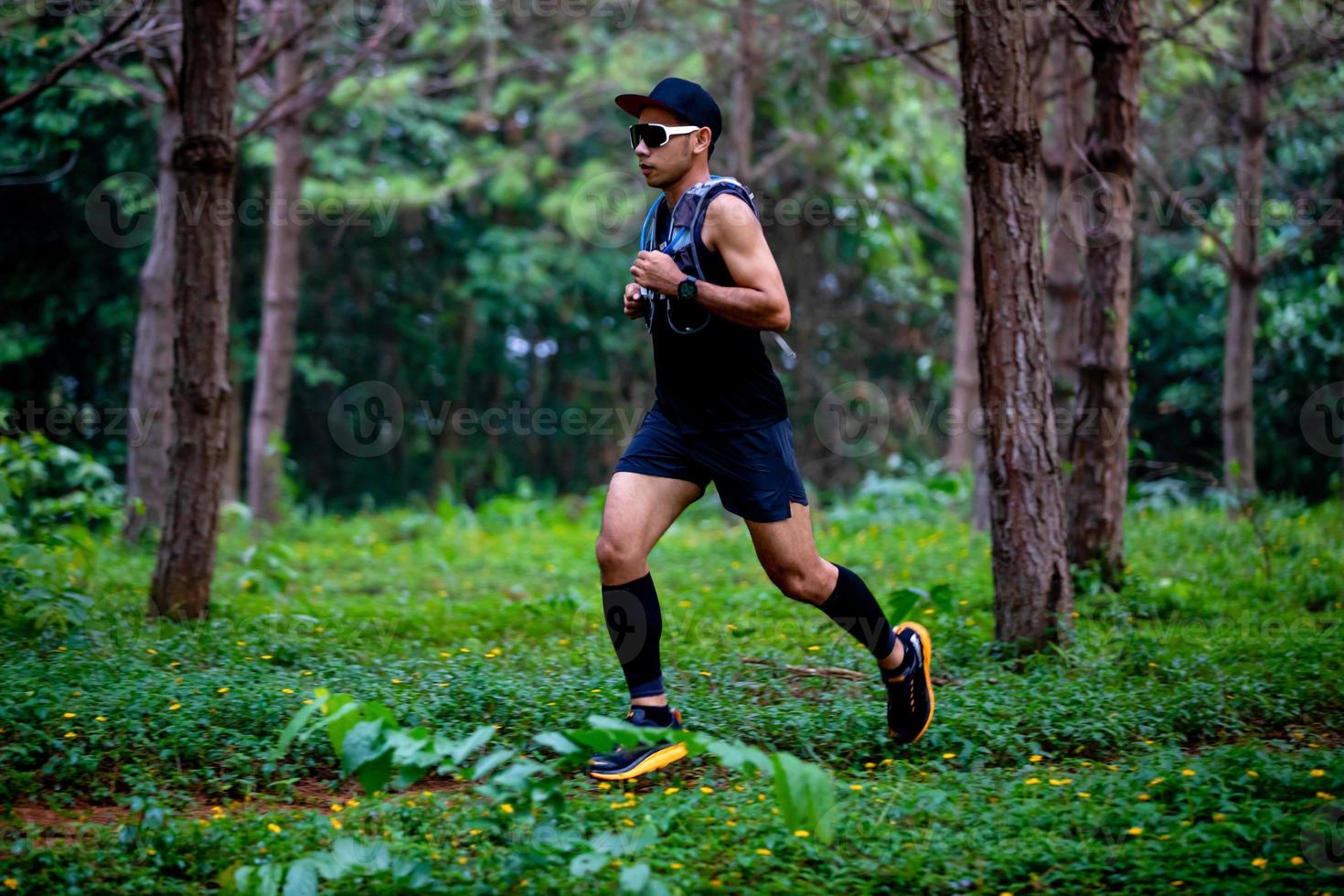 A man Runner of Trail and athlete's feet wearing sports shoes for trail running in the forest photo