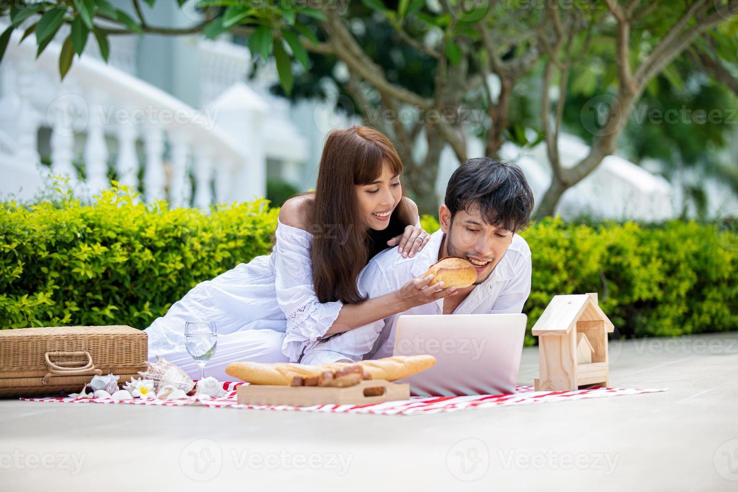 Happy Romantic Couples lover talking and drinking wine while having a picnic photo