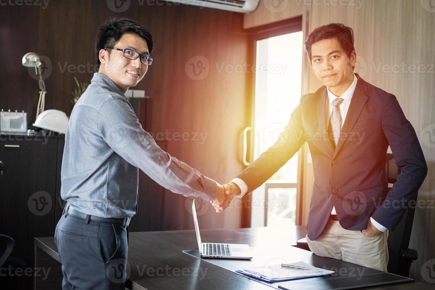 Asian Business people shaking hands and smiling their agreement to sign contract and finishing up a meeting photo