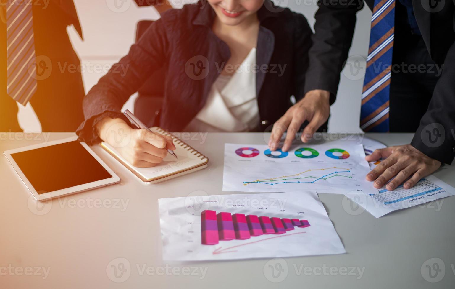 Asian businessmen and women working and point on graph financial diagram and analysis documents on office table photo