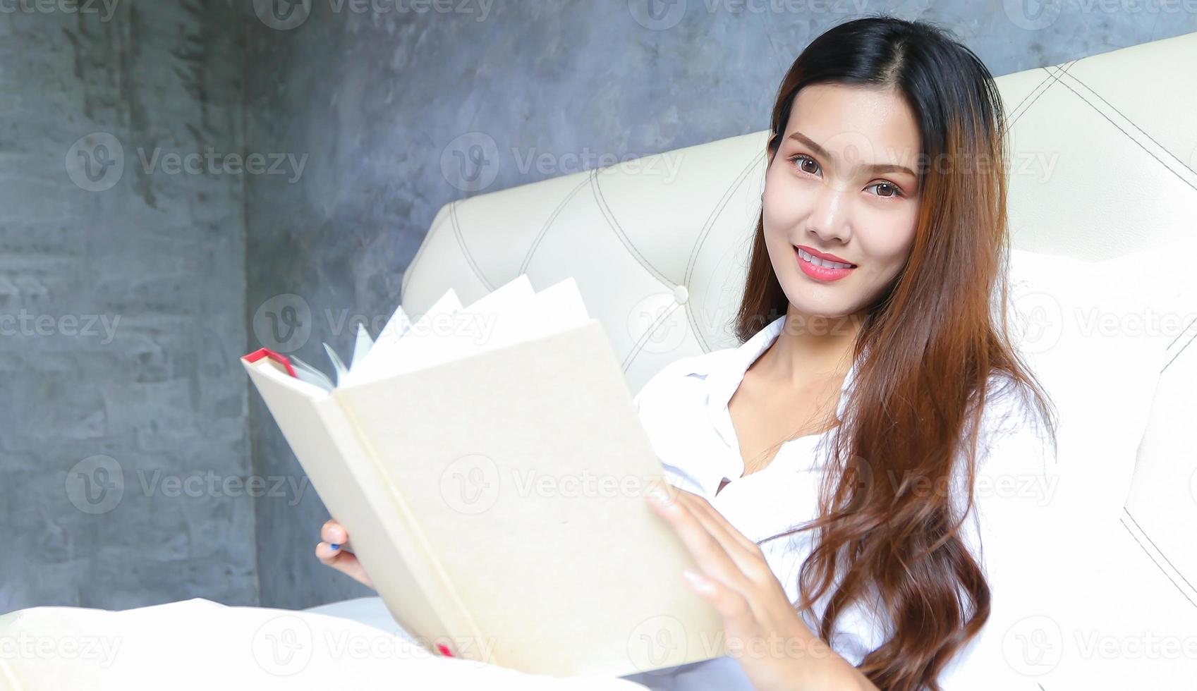 Asian woman reads her bed in the morning at home on a relaxing day. photo