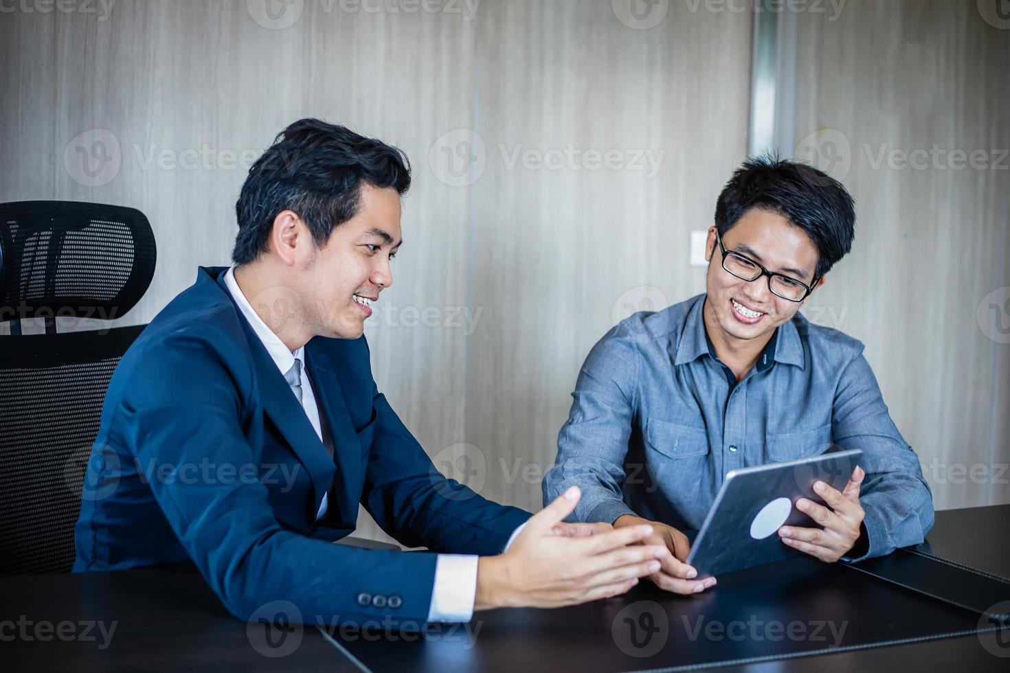 Asian businessmen and group using notebook for business partners discussing documents and ideas at meeting and business women smiling happy for working photo