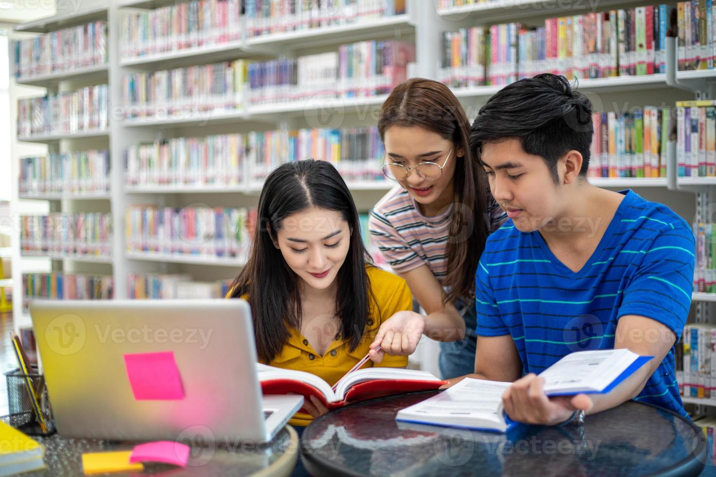 Group Asian  Students Smile and reading book and using notebook for helps to share ideas in the work and project. And also review the book before the exam photo