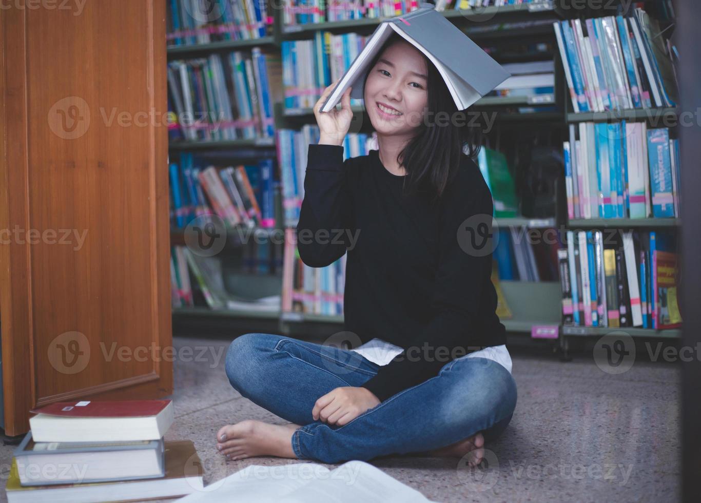 Asian girl students reading books and using notebook in the library. photo
