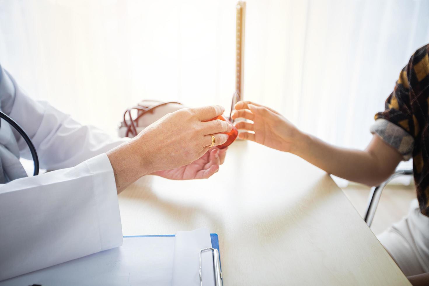 The doctor is asking and explaining the illness and giving the medicine. With female patients in his office at the hospital. photo