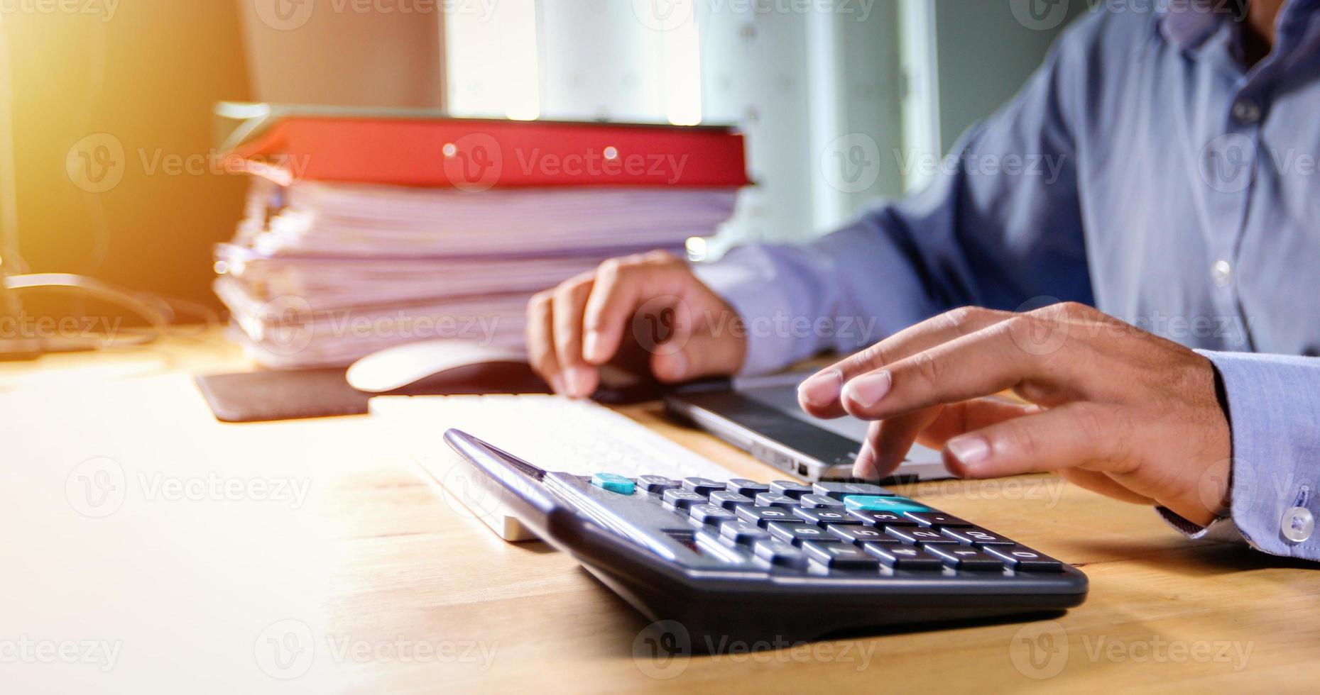 Businessmen are using calculators and analysis business data and and graph financial diagram working  at the meeting. photo