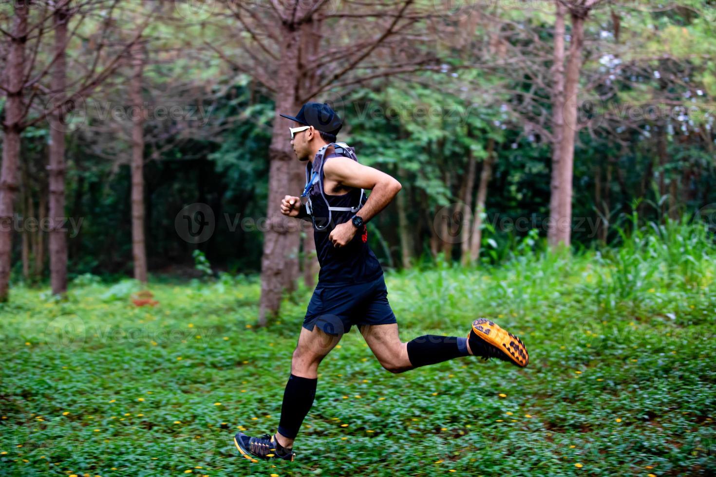 A man Runner of Trail and athlete's feet wearing sports shoes for trail running in the forest photo