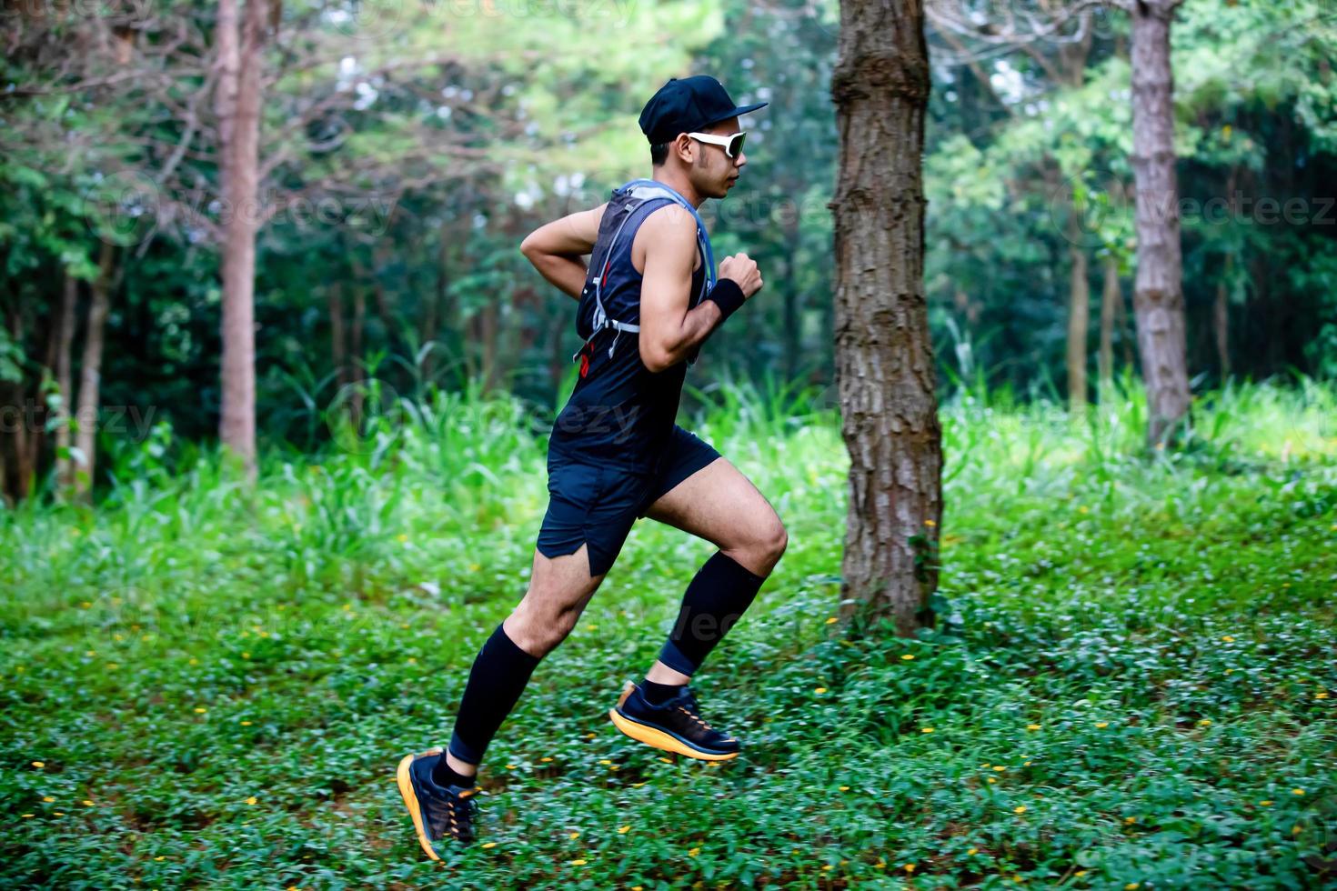 A man Runner of Trail and athlete's feet wearing sports shoes for trail running in the forest photo