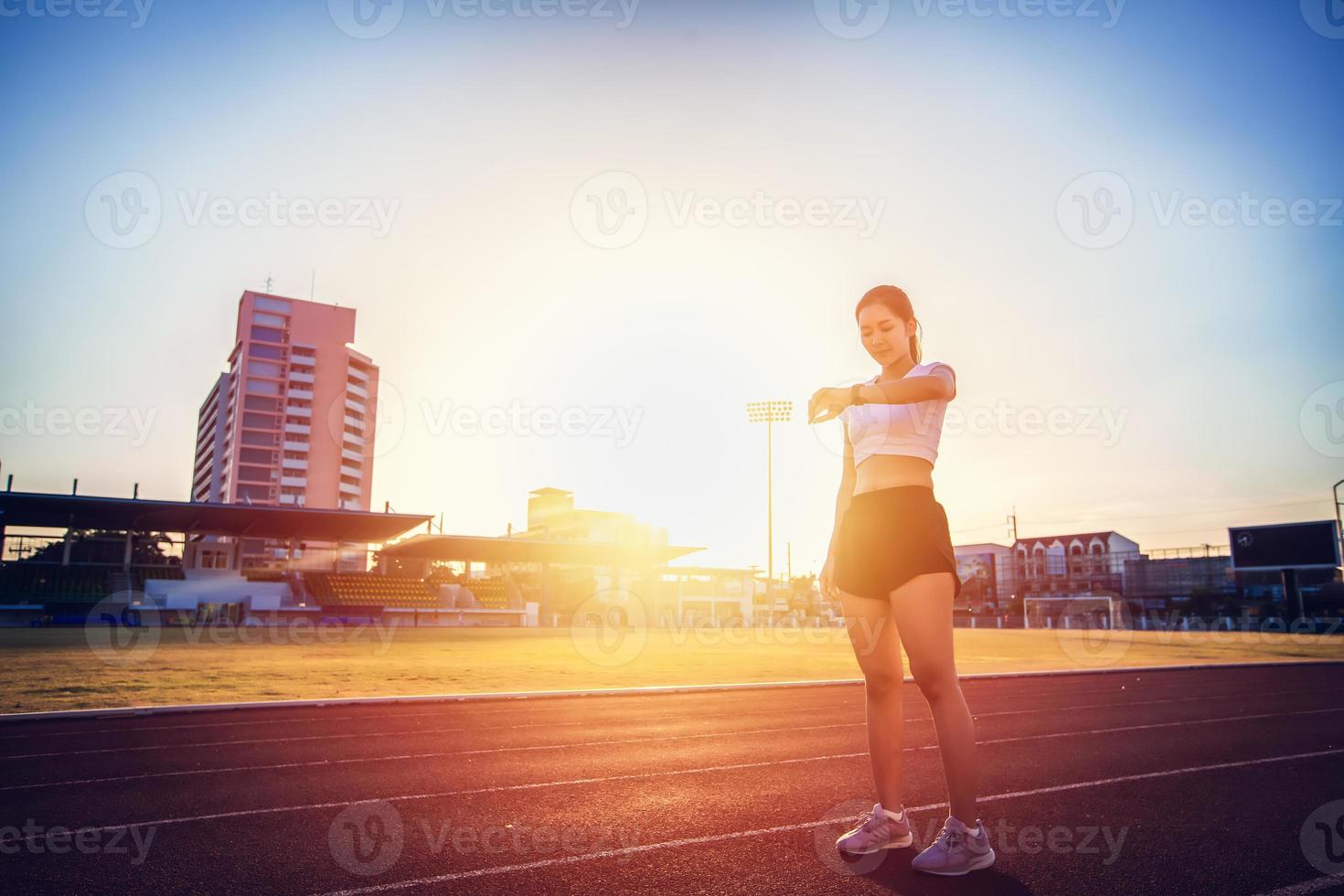 mujer asiática comprobando su desempeño en el reloj antes de correr foto