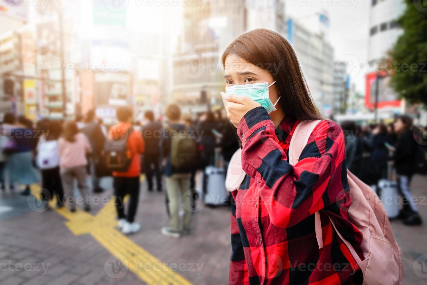 mujer joven asiática caminando en la ciudad con máscara de protección en la cara debido a la contaminación del aire, partículas y para proteger el virus de la gripe, la gripe, el coronavirus foto