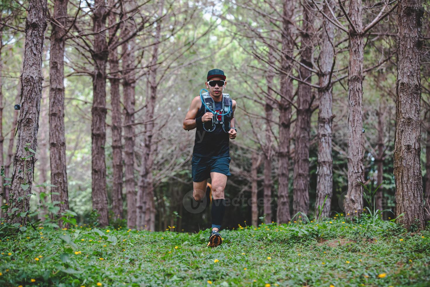 A man Runner of Trail and athlete's feet wearing sports shoes for trail running in the forest photo