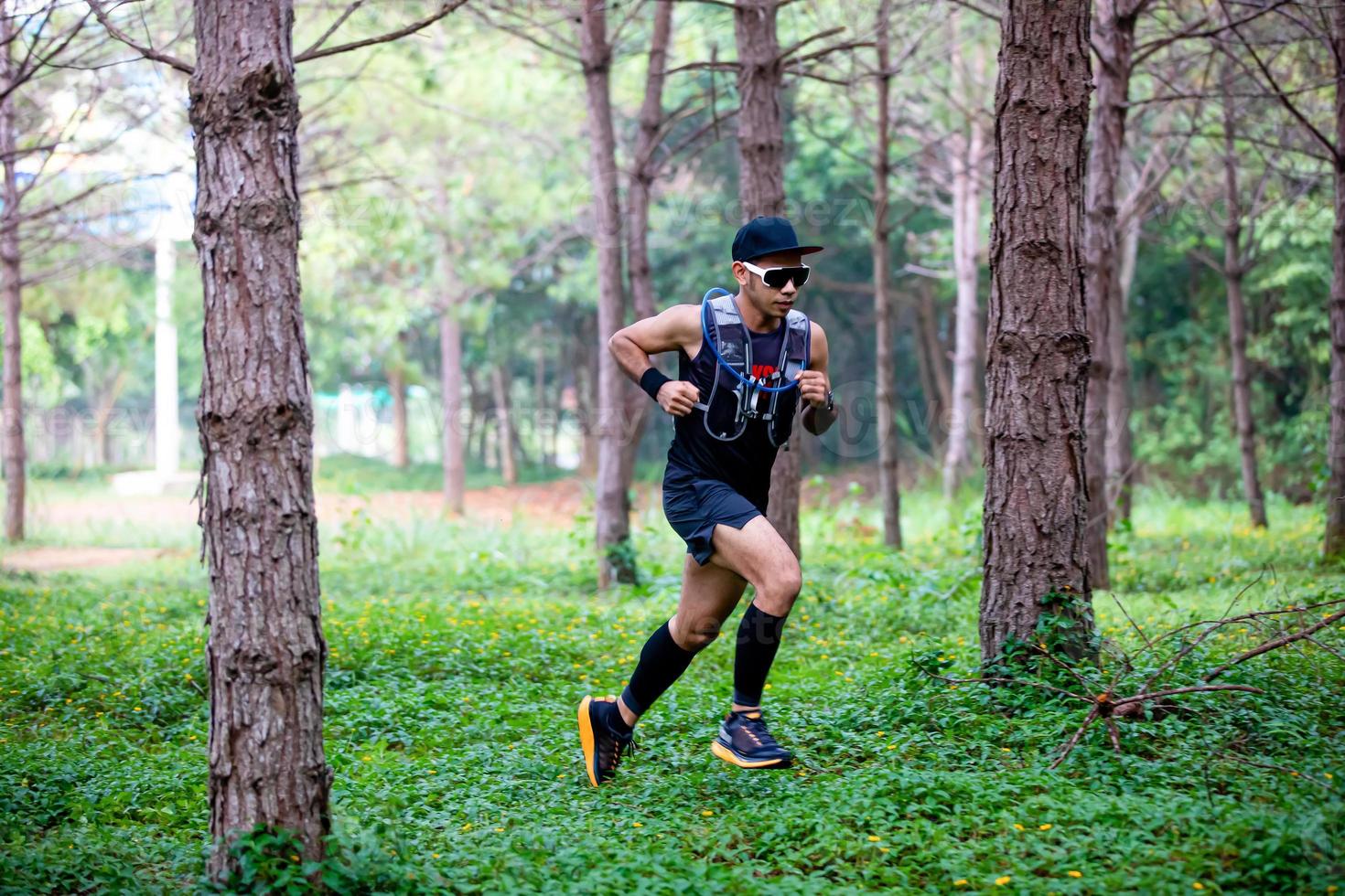 A man Runner of Trail and athlete's feet wearing sports shoes for trail running in the forest photo