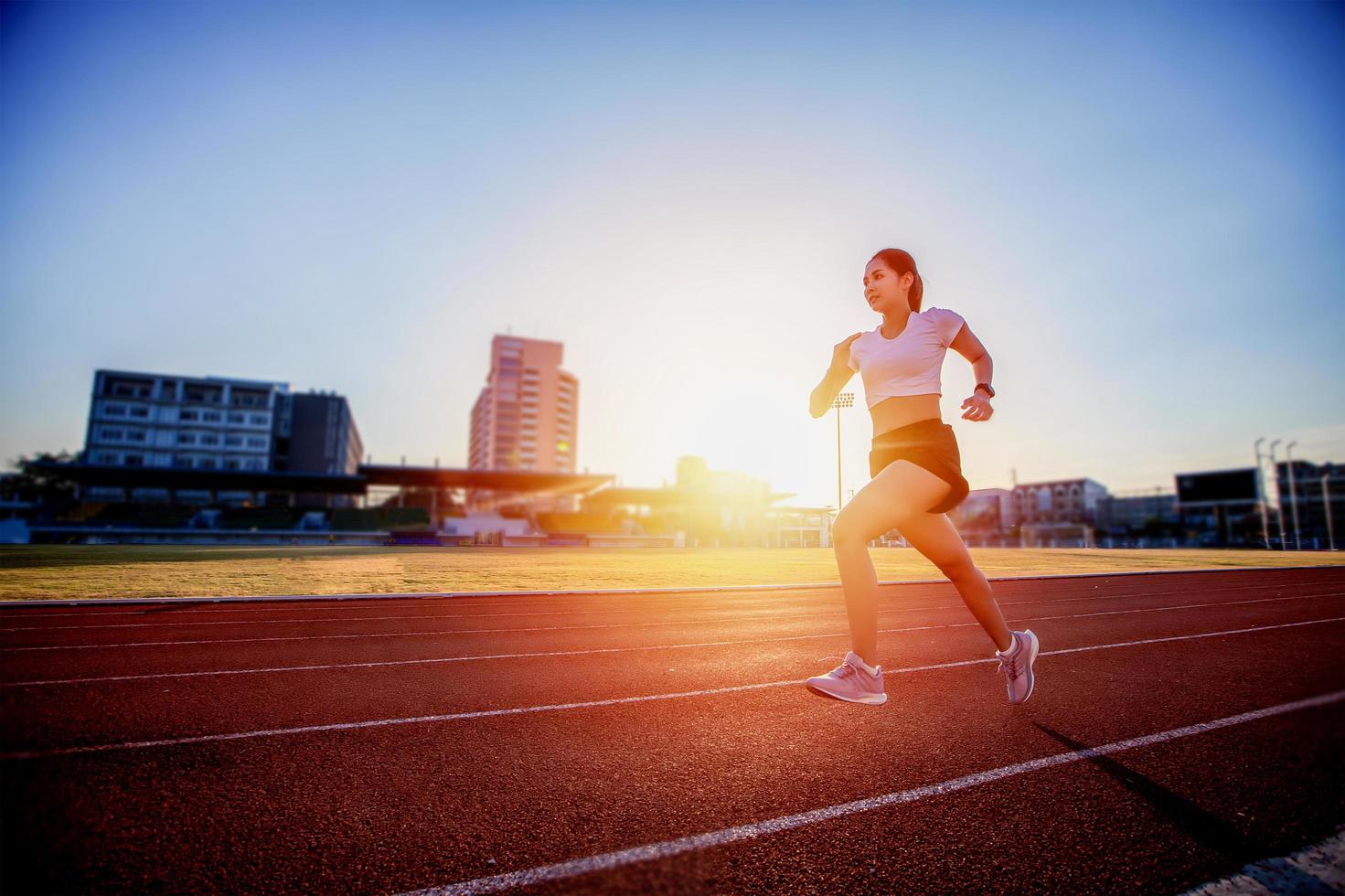 Asian Young fitness woman runner running on stadium track photo