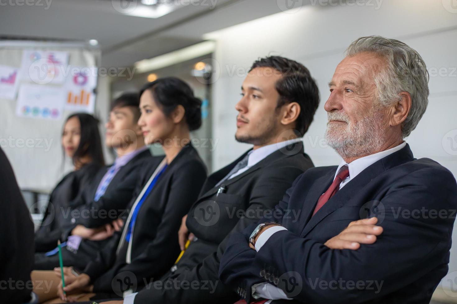 la gente de negocios se sienta y escucha el seminario en la sala de reuniones foto