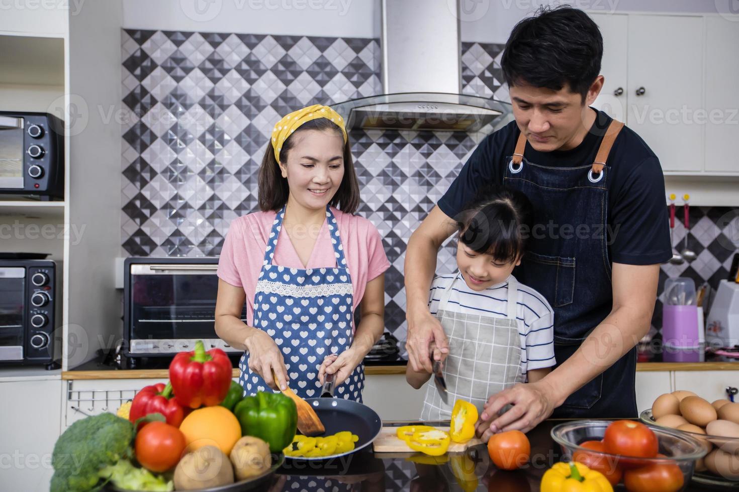 Asian families are cooking and parents are teaching their daughters to cook in the kitchen at home. Family activities on holidays and Happy in recreation concept photo