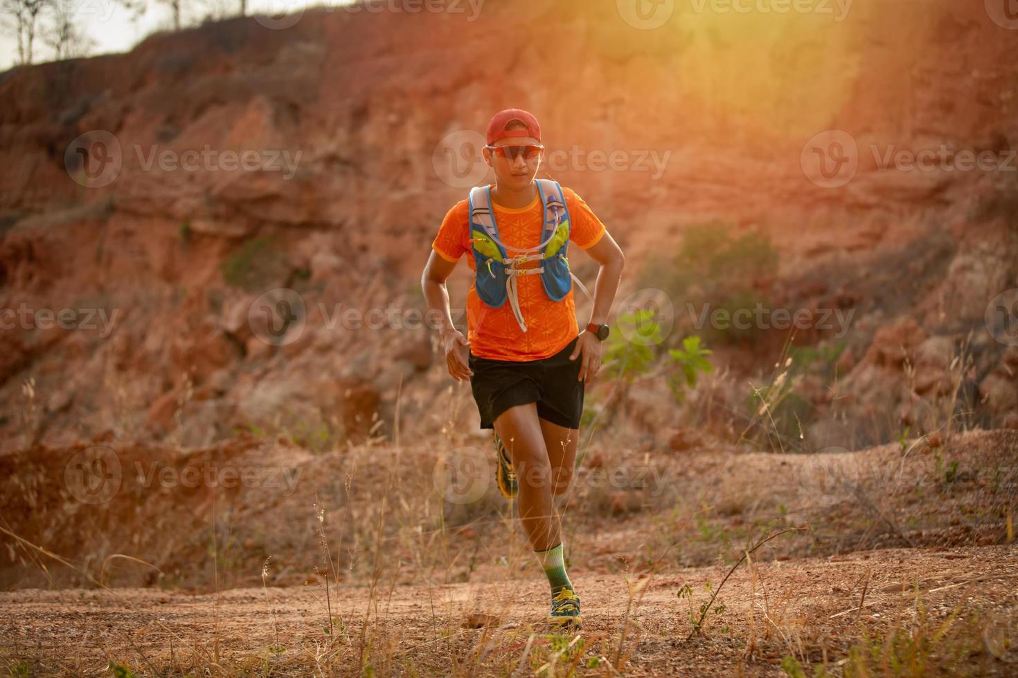 A man Runner of Trail and athlete's feet wearing sports shoes for trail running in the mountain photo