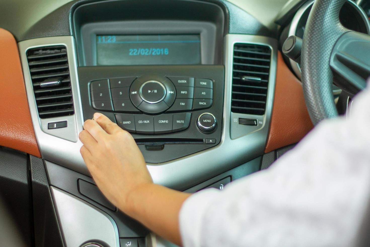 Las mujeres asiáticas presionan el botón de la radio del coche para escuchar música. foto