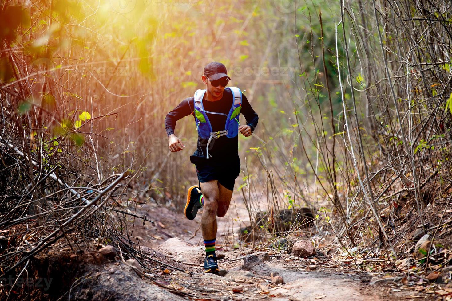 A man Runner of Trail and athlete's feet wearing sports shoes for trail running in the forest photo