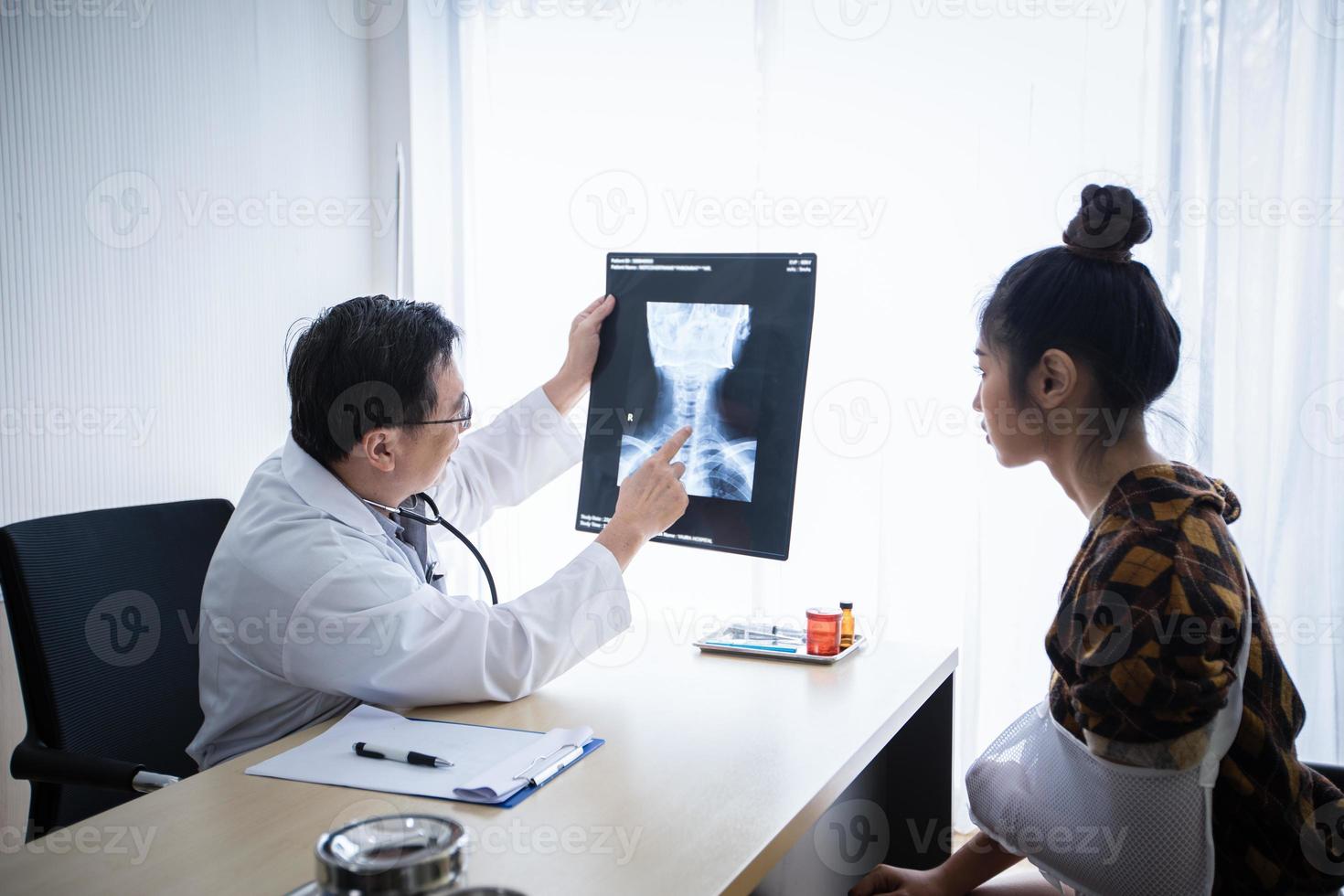 The doctor is explaining about the brain X-ray results to a female patient lying in bed at a hospital photo