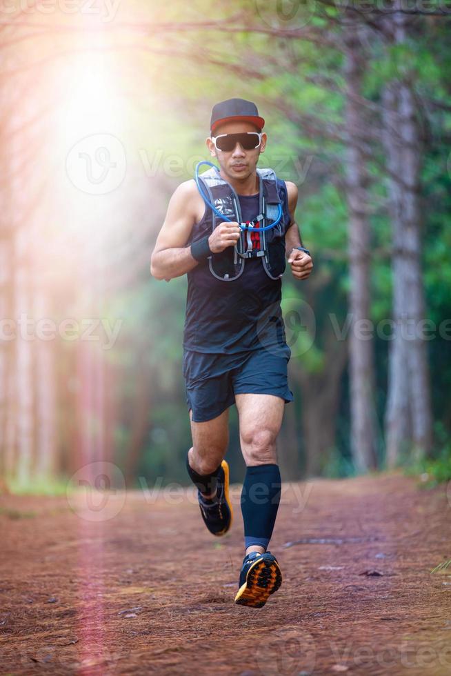 A man Runner of Trail and athlete's feet wearing sports shoes for trail running in the forest photo