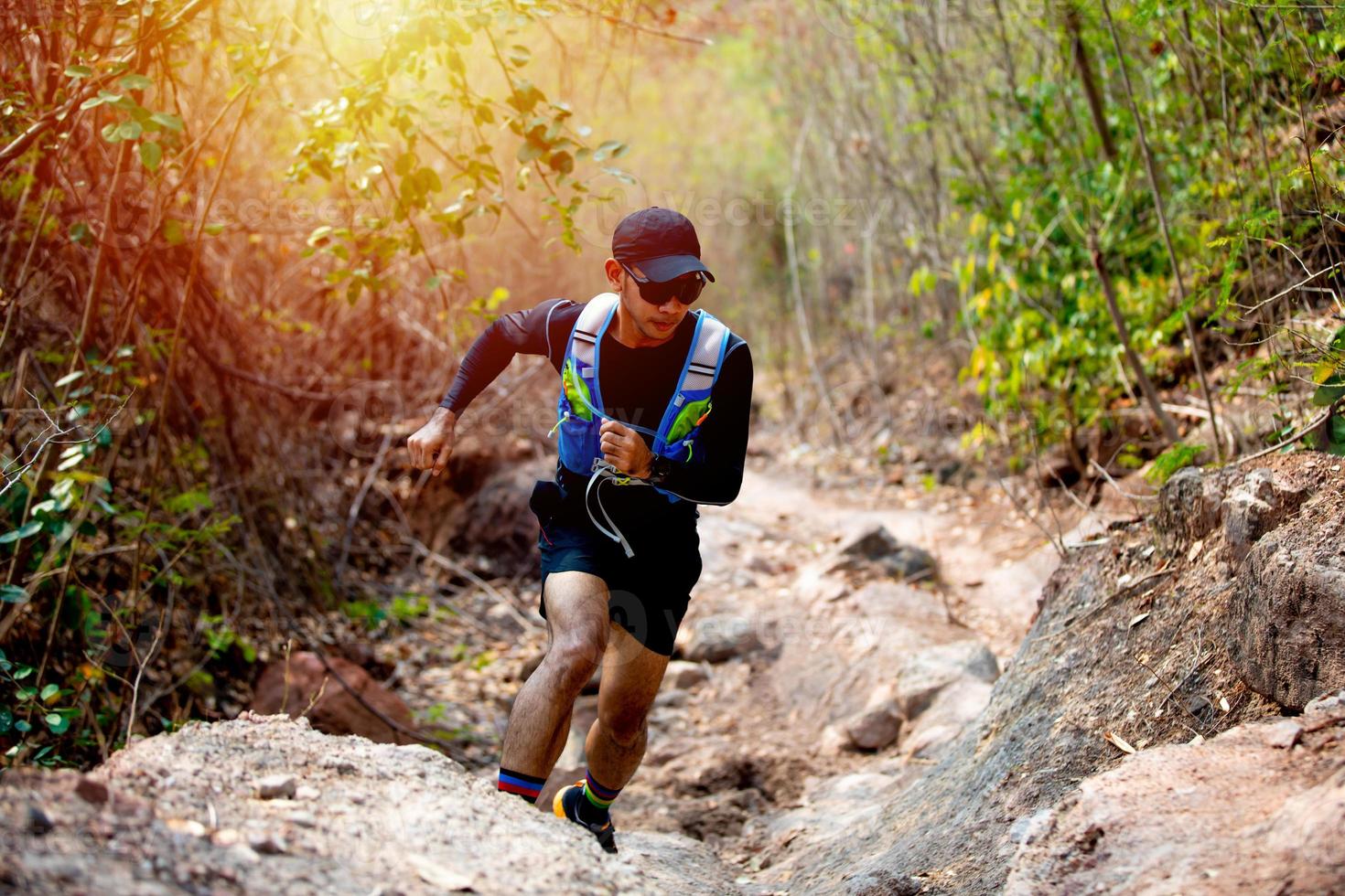 A man Runner of Trail and athlete's feet wearing sports shoes for trail running in the forest photo
