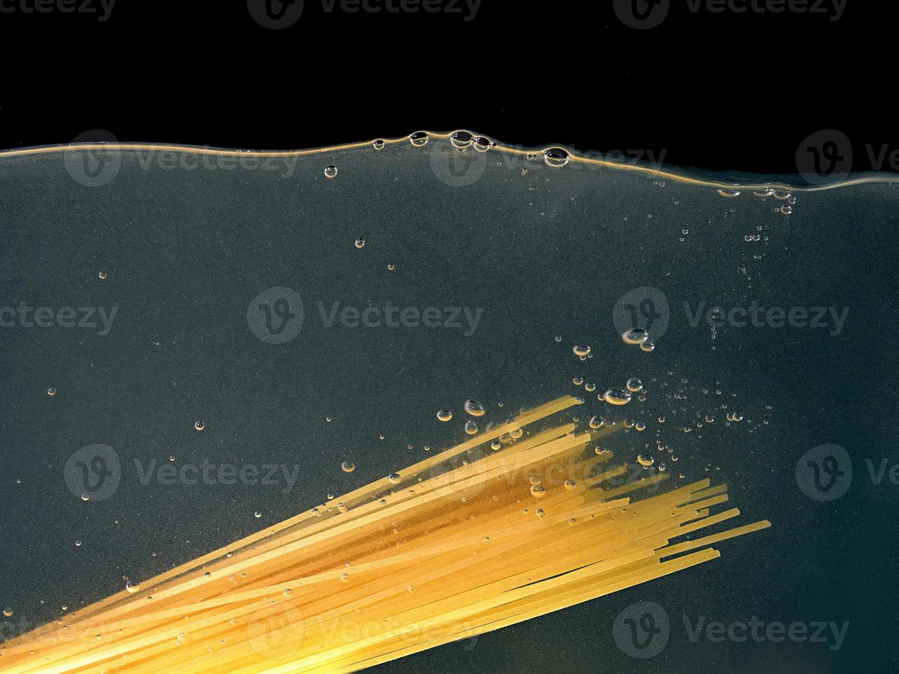 espaguetis en una cacerola sobre fondo oscuro. vista submarina. cocinar, cocinar en casa foto