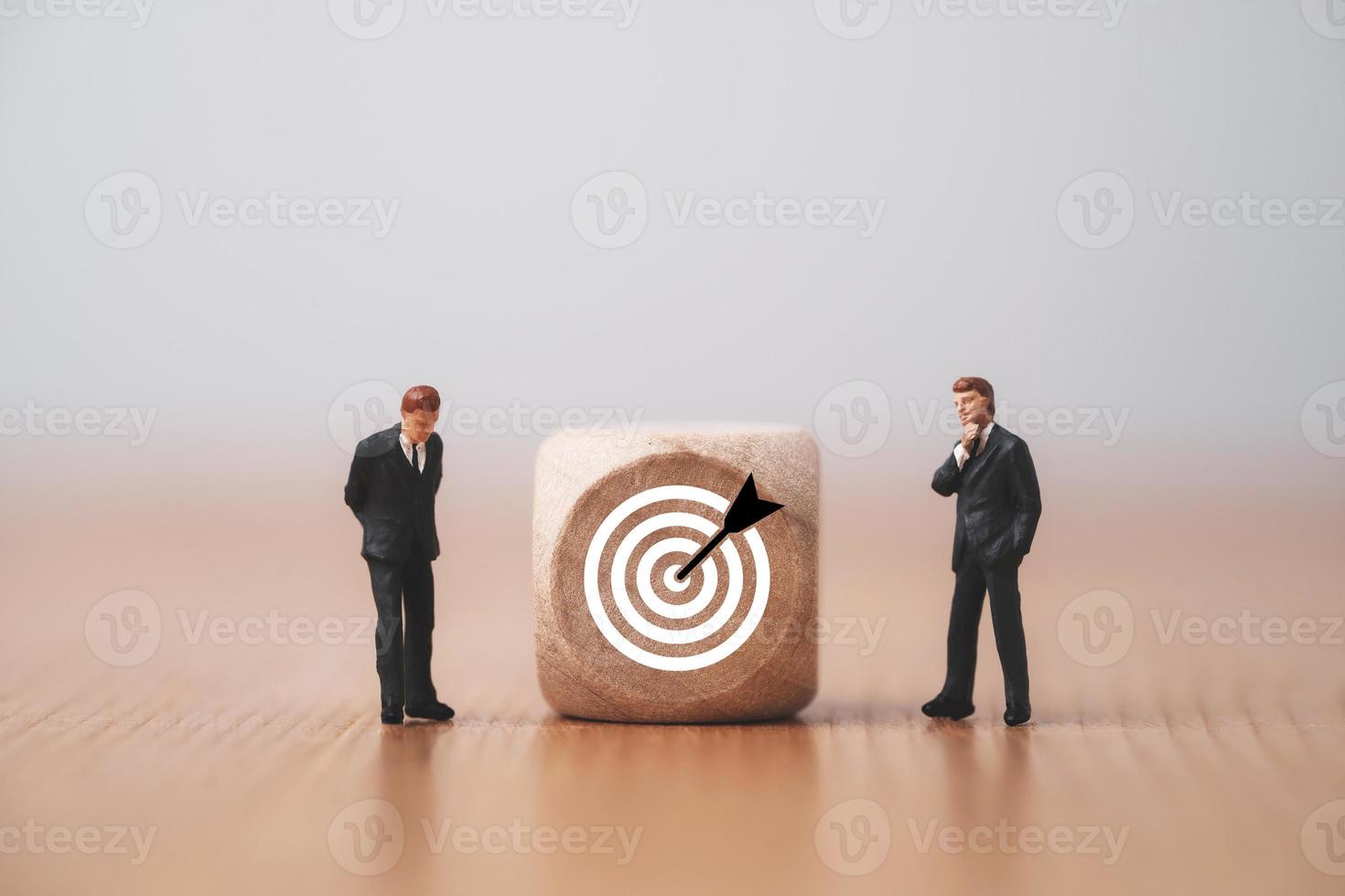 Miniature businessmen figure standing and thinking with cube and target board for setup objective target concept. photo