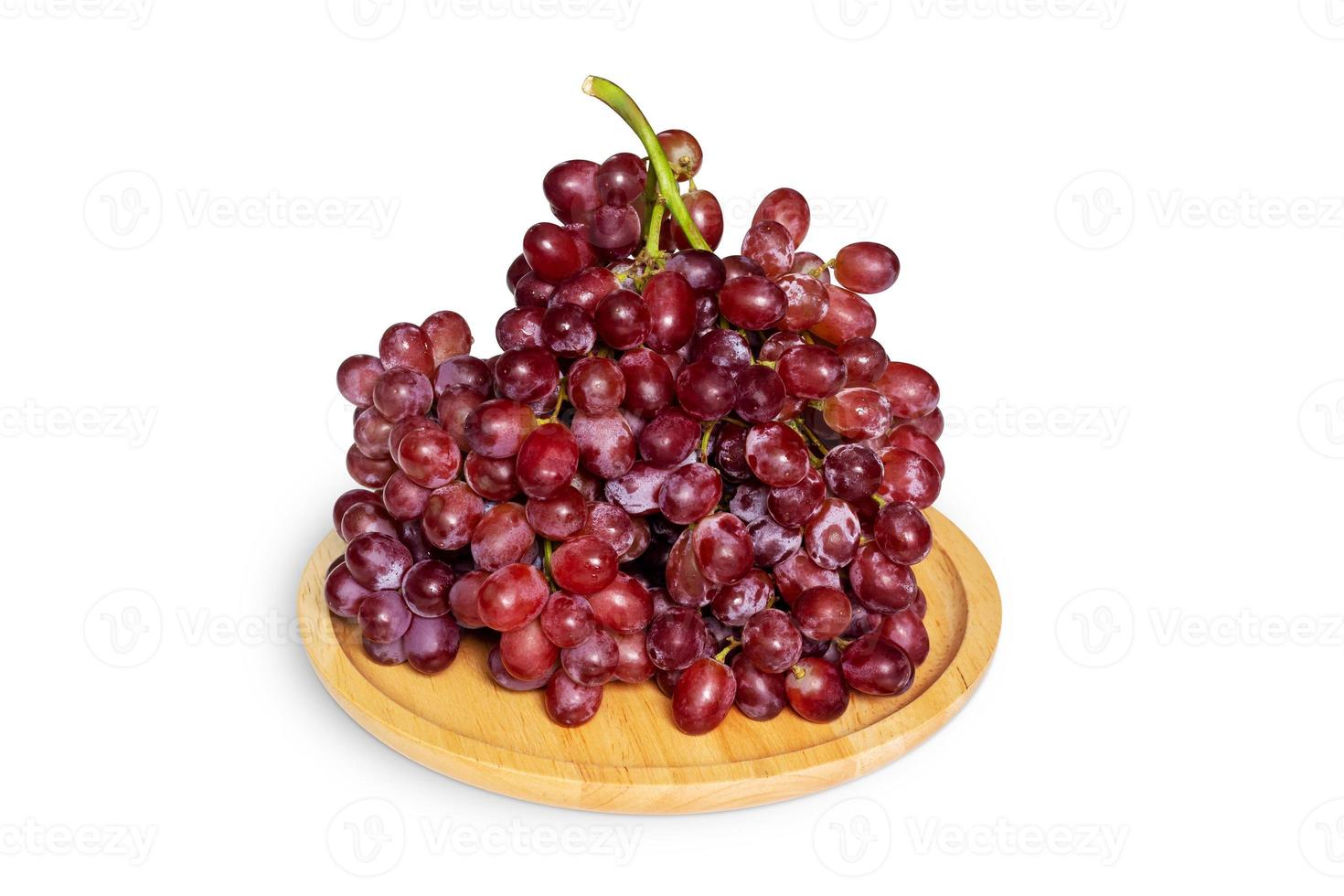 Red grapes in the wooden plate isolated on a white background with clipping path. photo