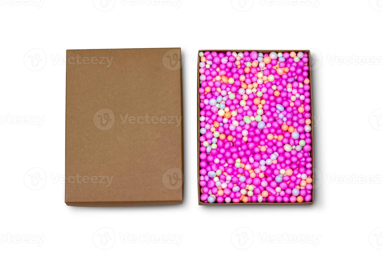 Top view of carton isolated on a white background with clipping path. Brown cardboard delivery box. Open surprise box with colorful foam beads. photo