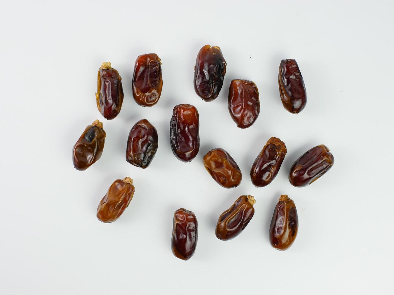 dates scattered isolated on a white background. healthy fruit ramadan concept photo