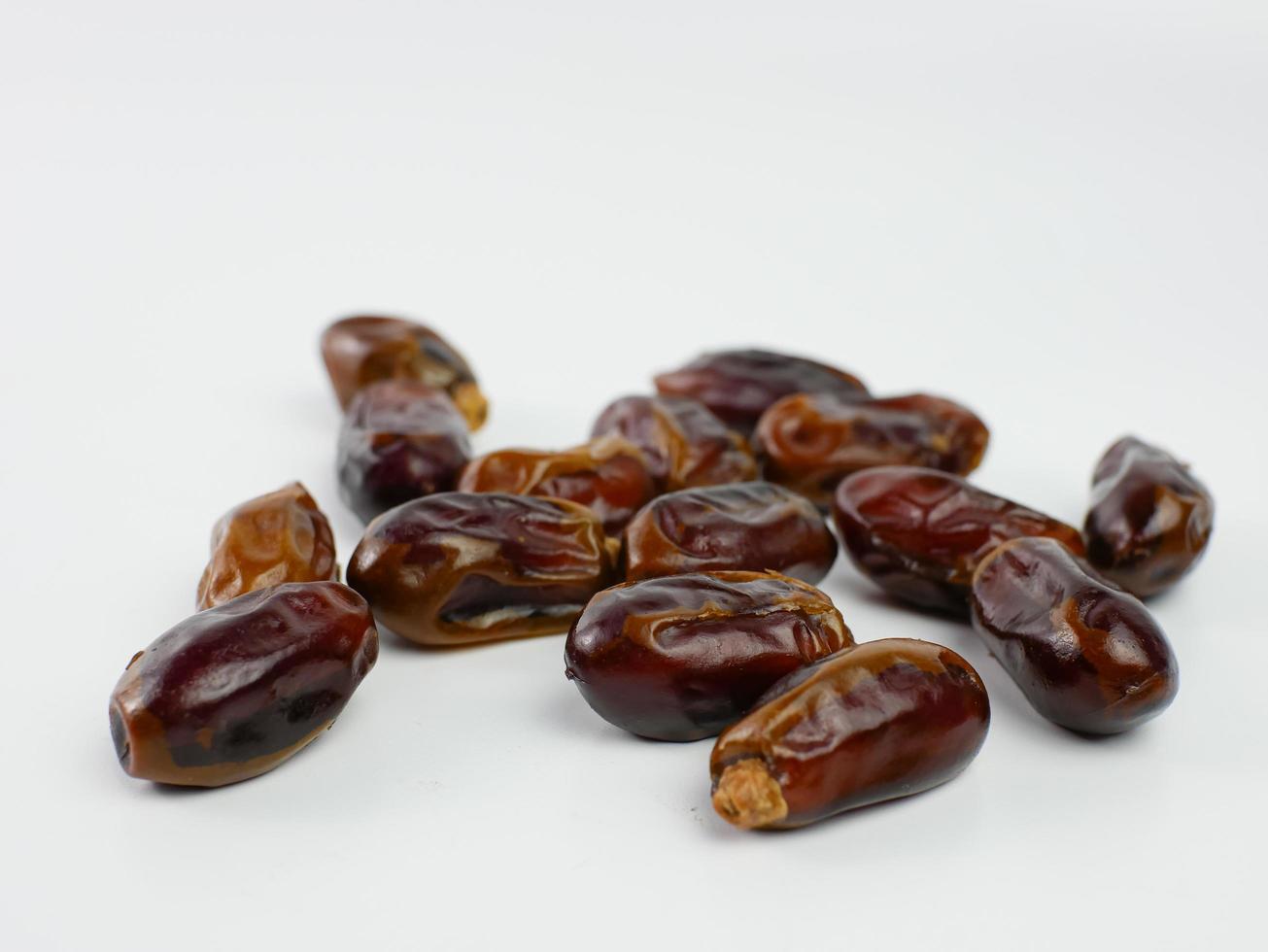 dates scattered isolated on a white background. healthy fruit ramadan concept photo