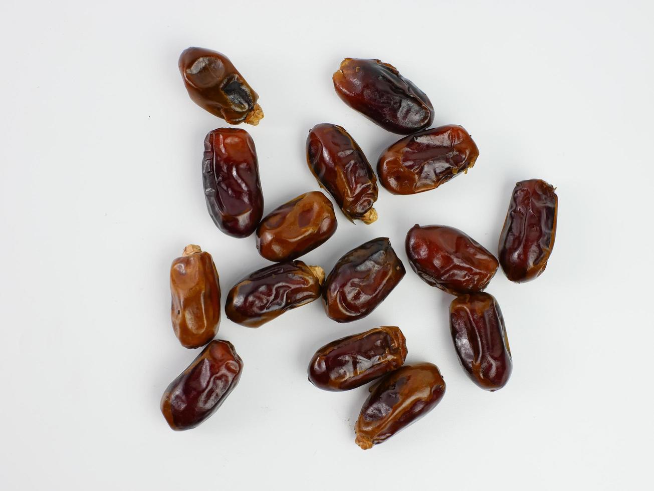 dates scattered isolated on a white background. healthy fruit ramadan concept photo