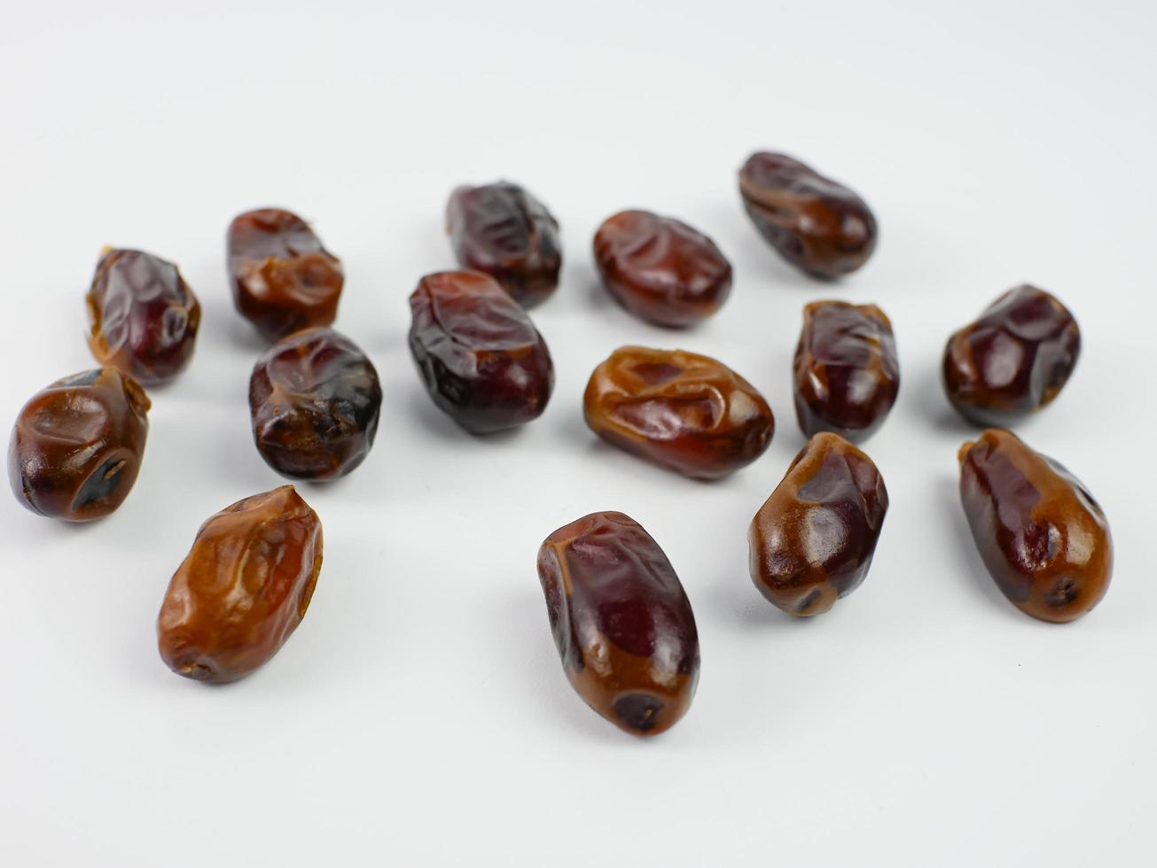dates scattered isolated on a white background. healthy fruit ramadan concept photo