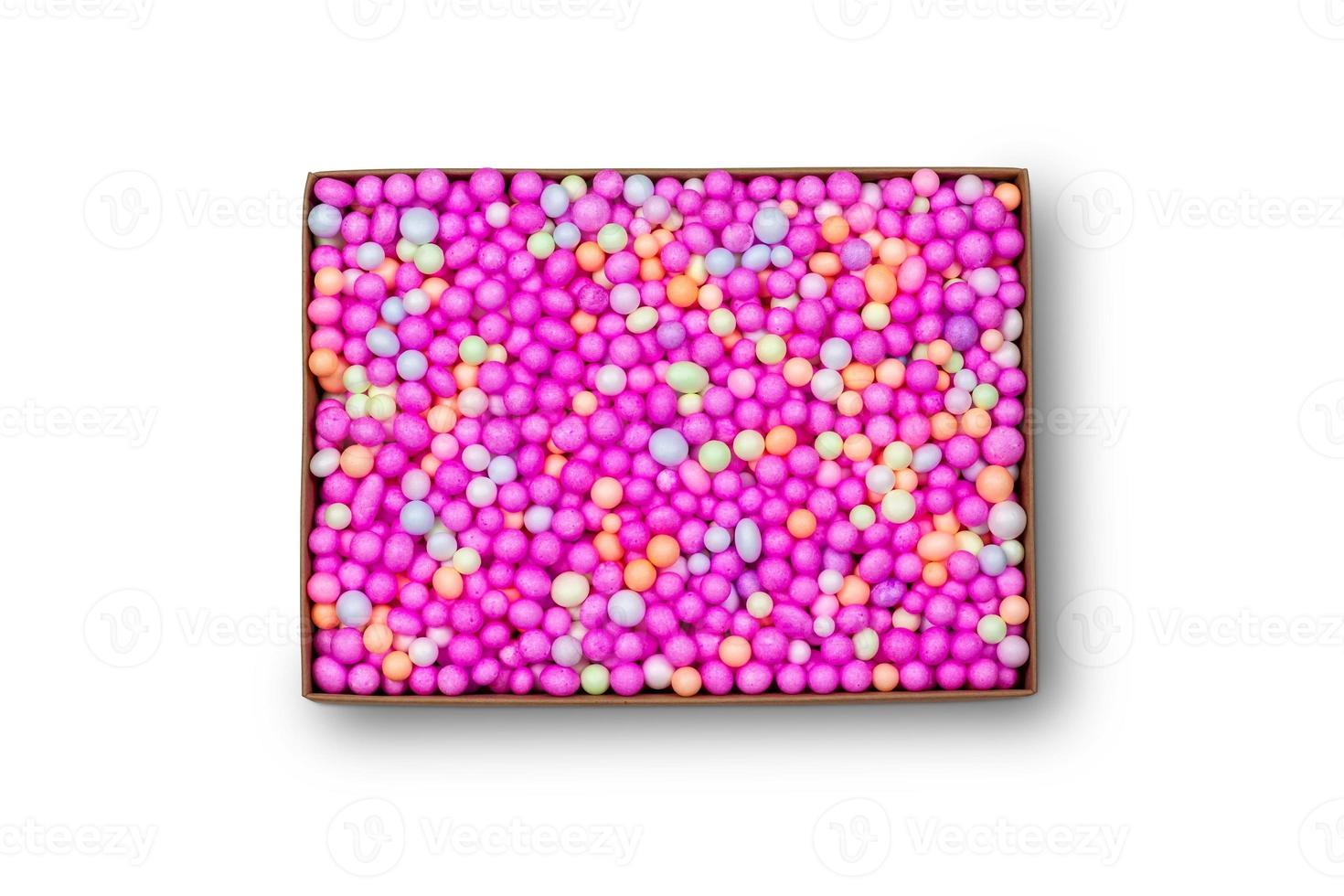 Top view of carton isolated on a white background with clipping path. Brown cardboard delivery box. Open surprise box with colorful foam beads. photo