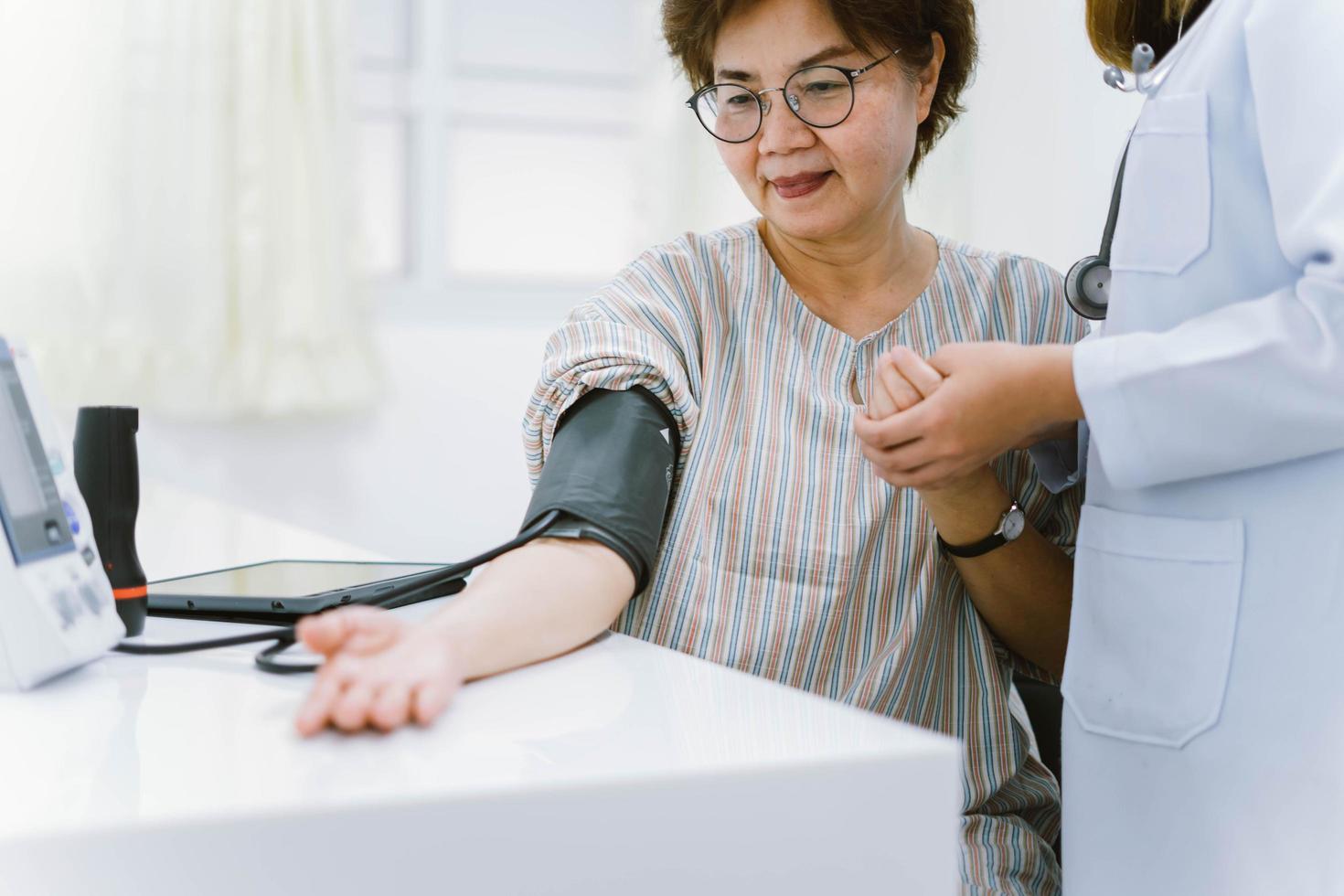 close up doctor checking senior patient blood pressure. Health care. photo