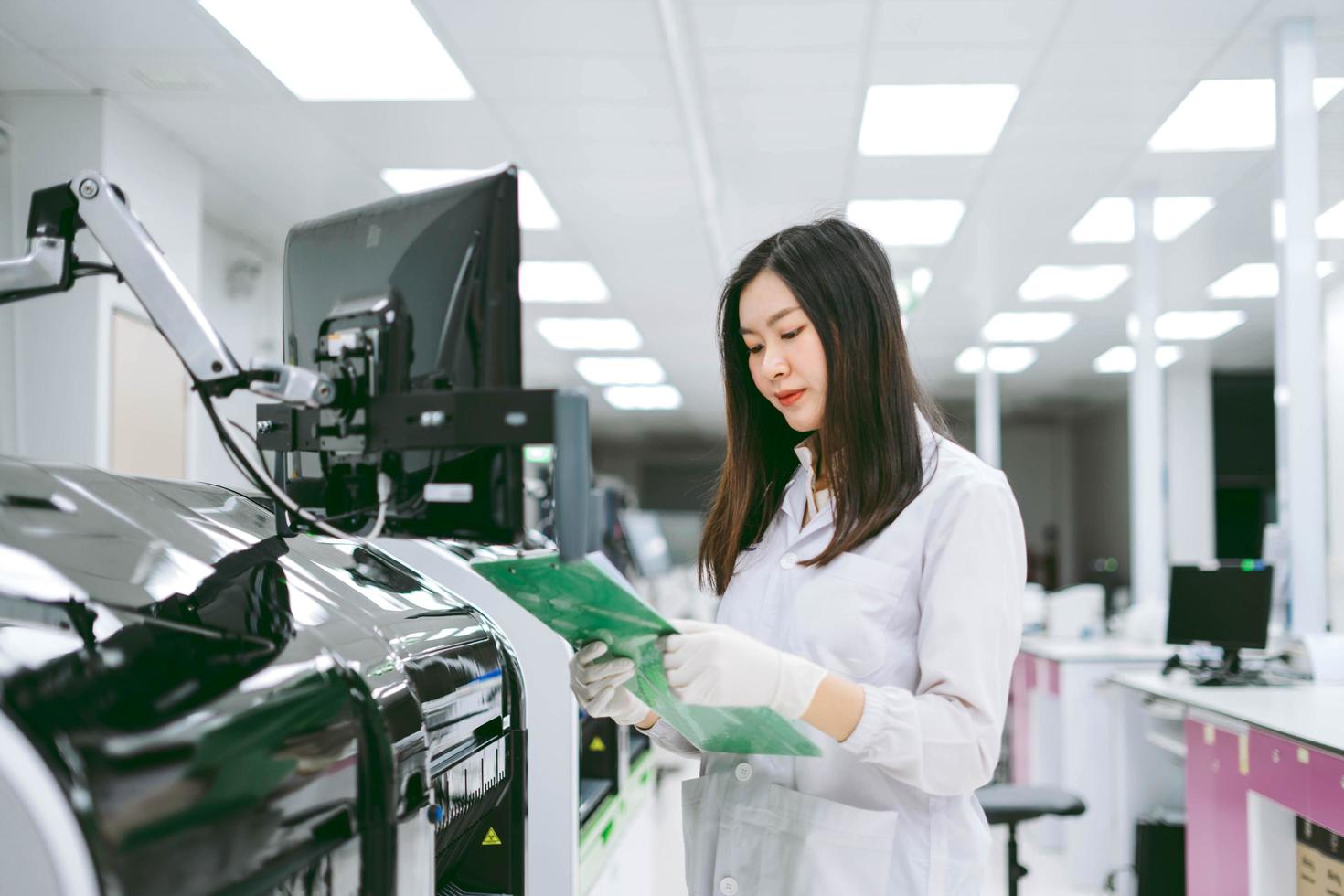 joven científica nota los resultados del informe del analizador de sangre de automatización en el laboratorio médico foto