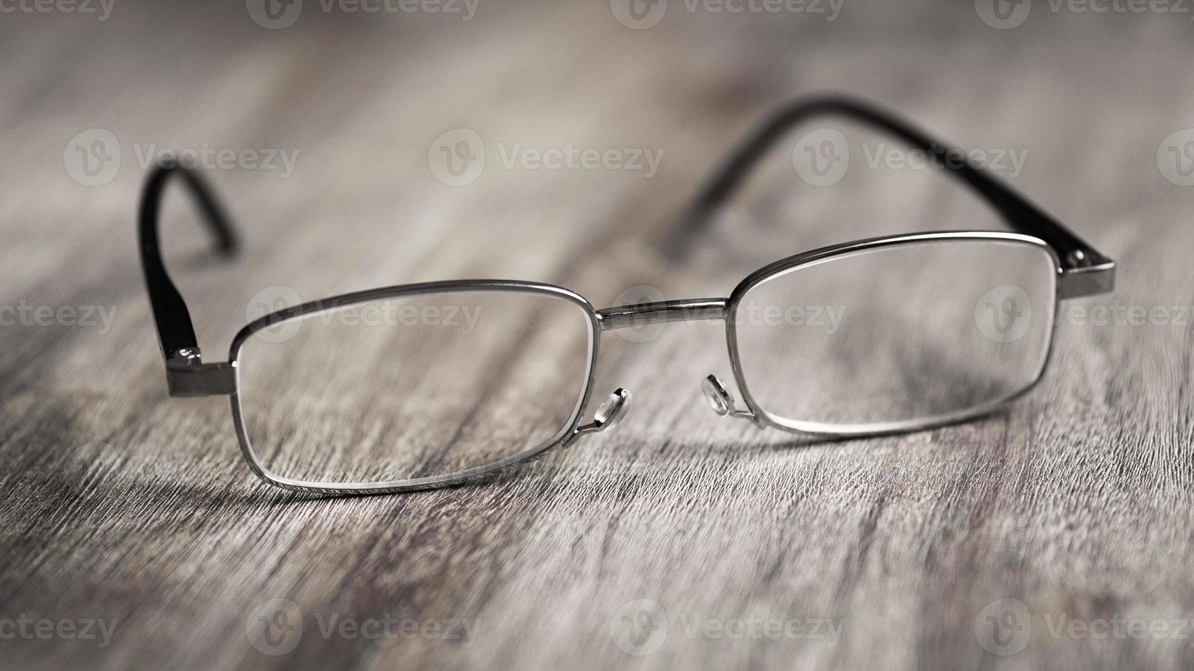 reading glasses on wooden table photo