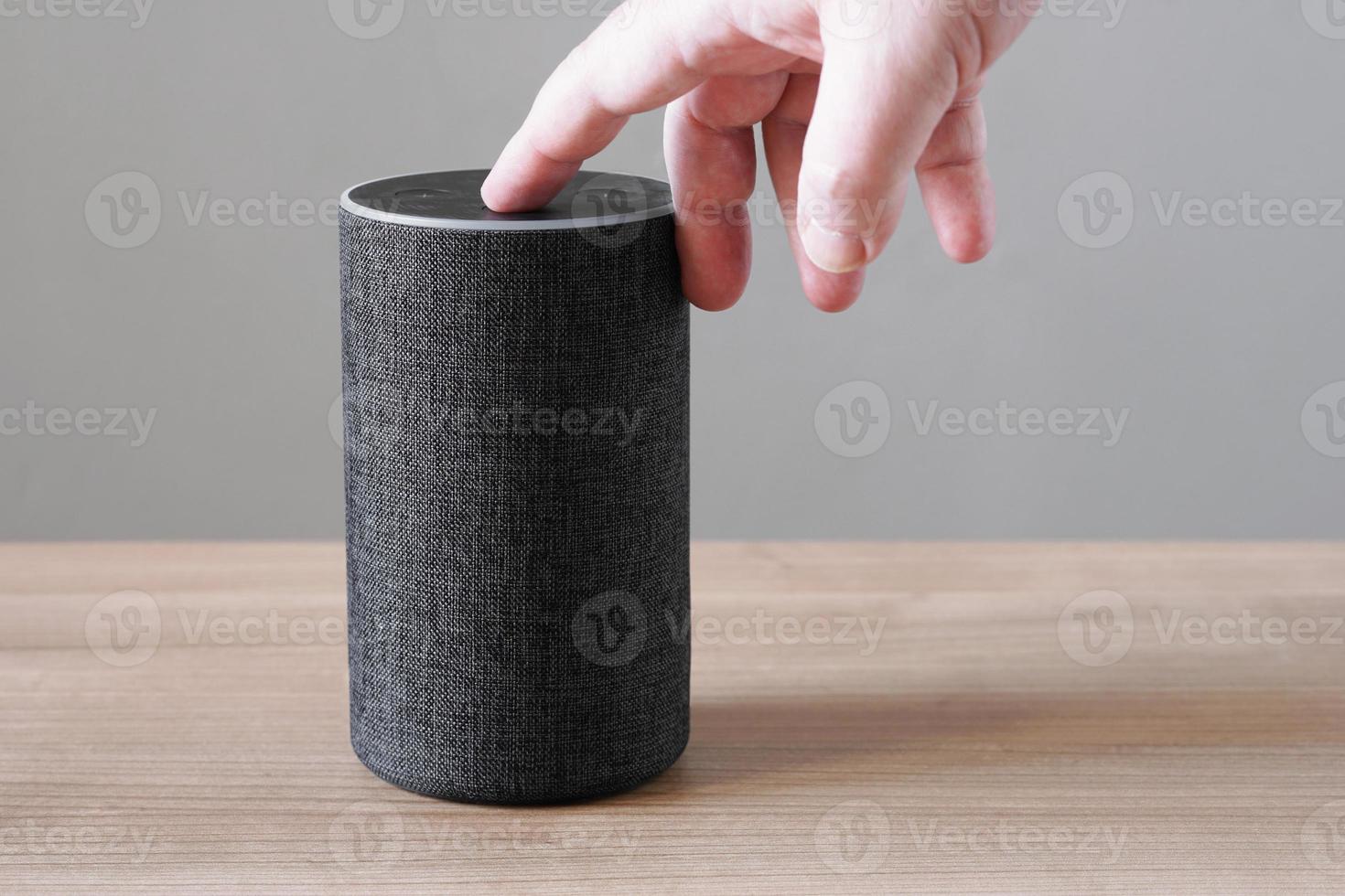 hand turning off smart speaker microphone photo