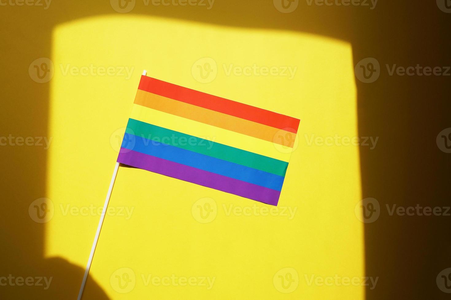 rainbow flag gay or lgbt pride symbol against yellow background with shadow frame photo